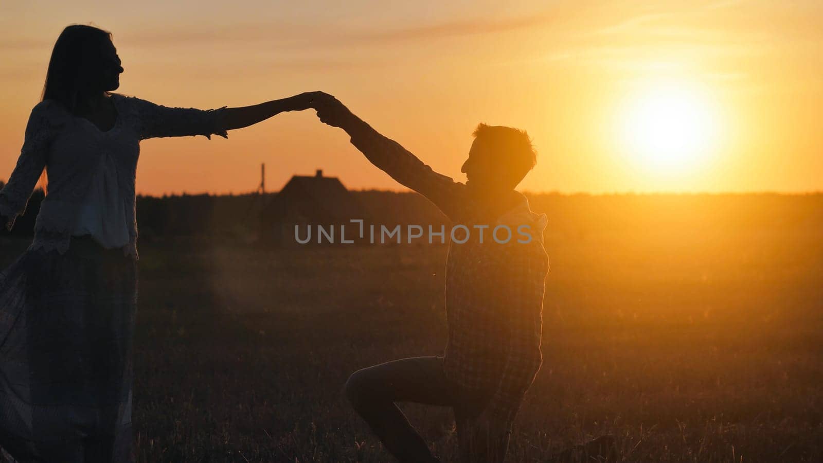 Silhouettes of a dancing couple in love at sunset