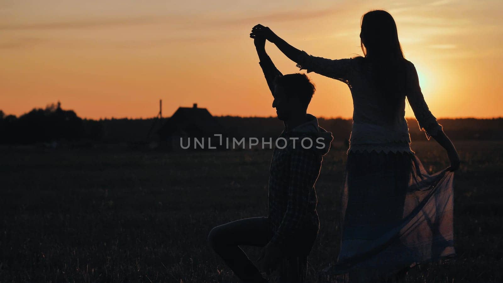 Silhouettes of a dancing couple in love at sunset