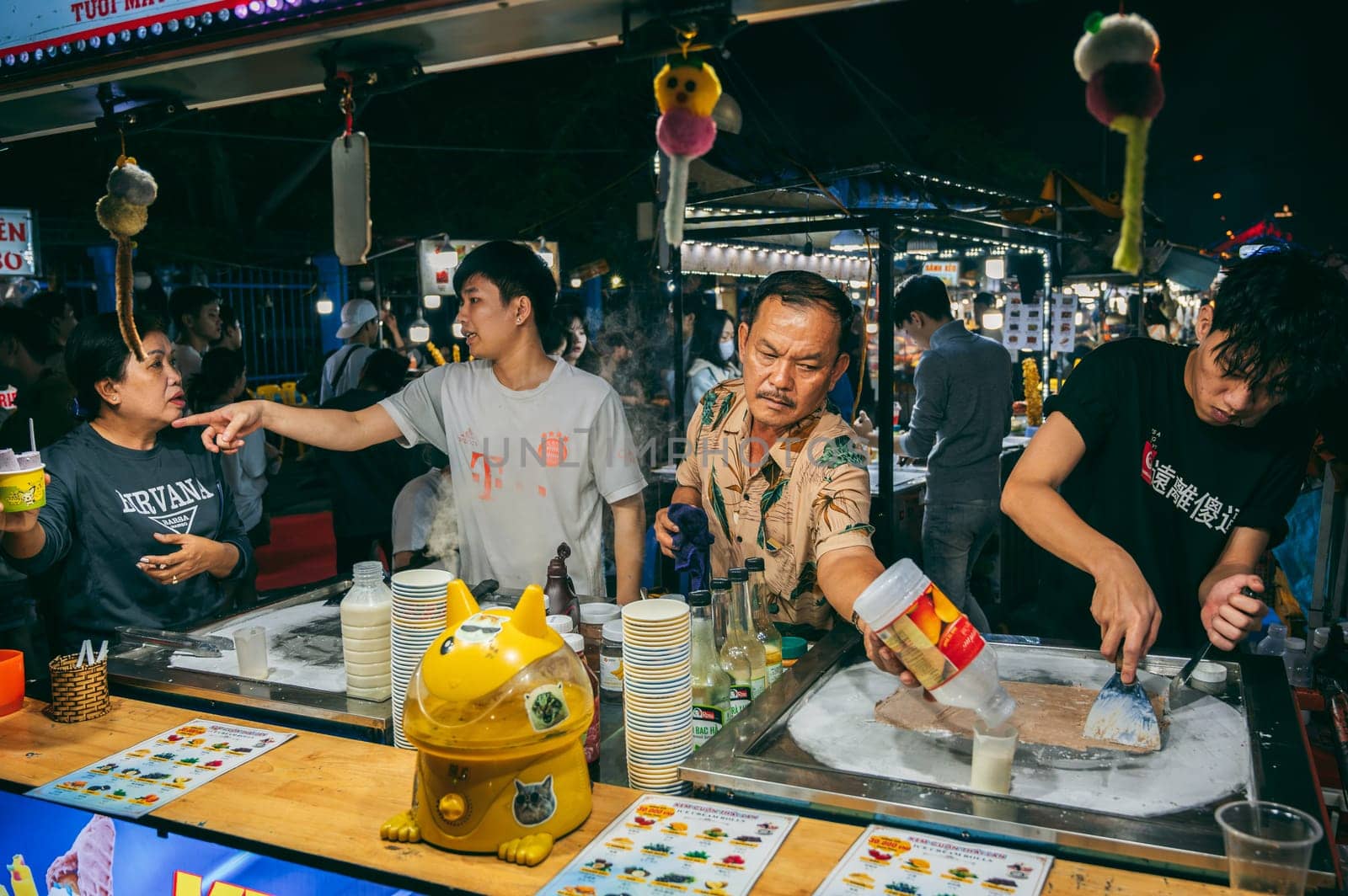 Vietnamese chefs and vendors make ice cream at a Night market street food stand in Da Nang in Asia. Da Nang, Vietnam - November 30, 2024