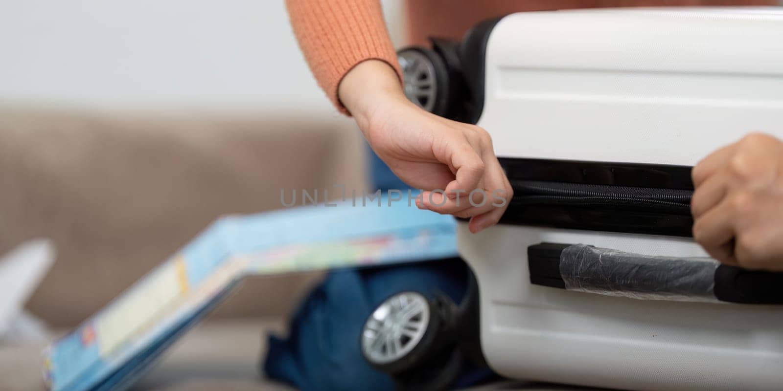 The child excitedly engages in packing a suitcase, illustrating the thrill of travel with maps and travel-related items in focus.