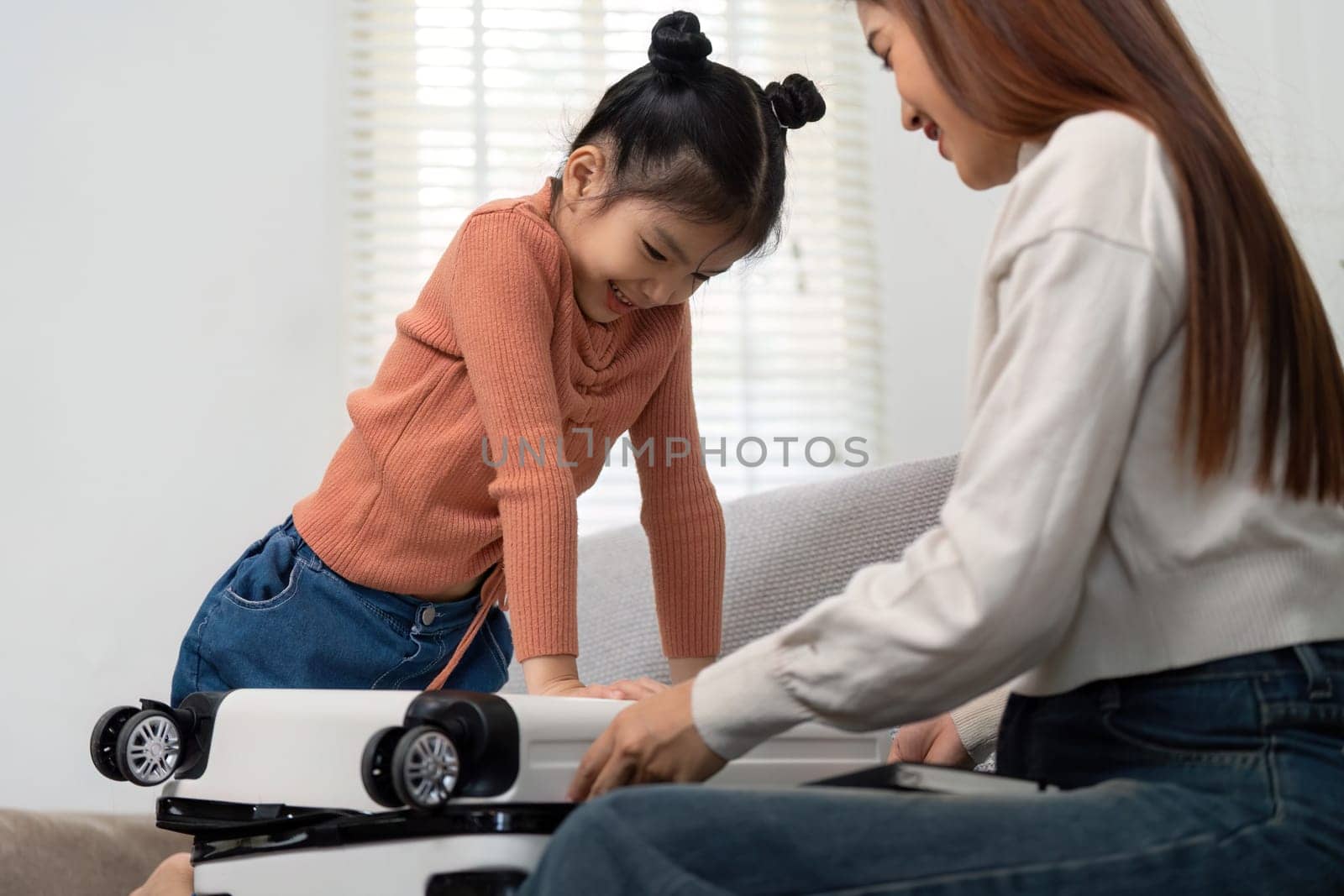 The image showcases a little girl eagerly involved in packing, offering a glimpse into the excitement and bonding moments that make travel preparations special.