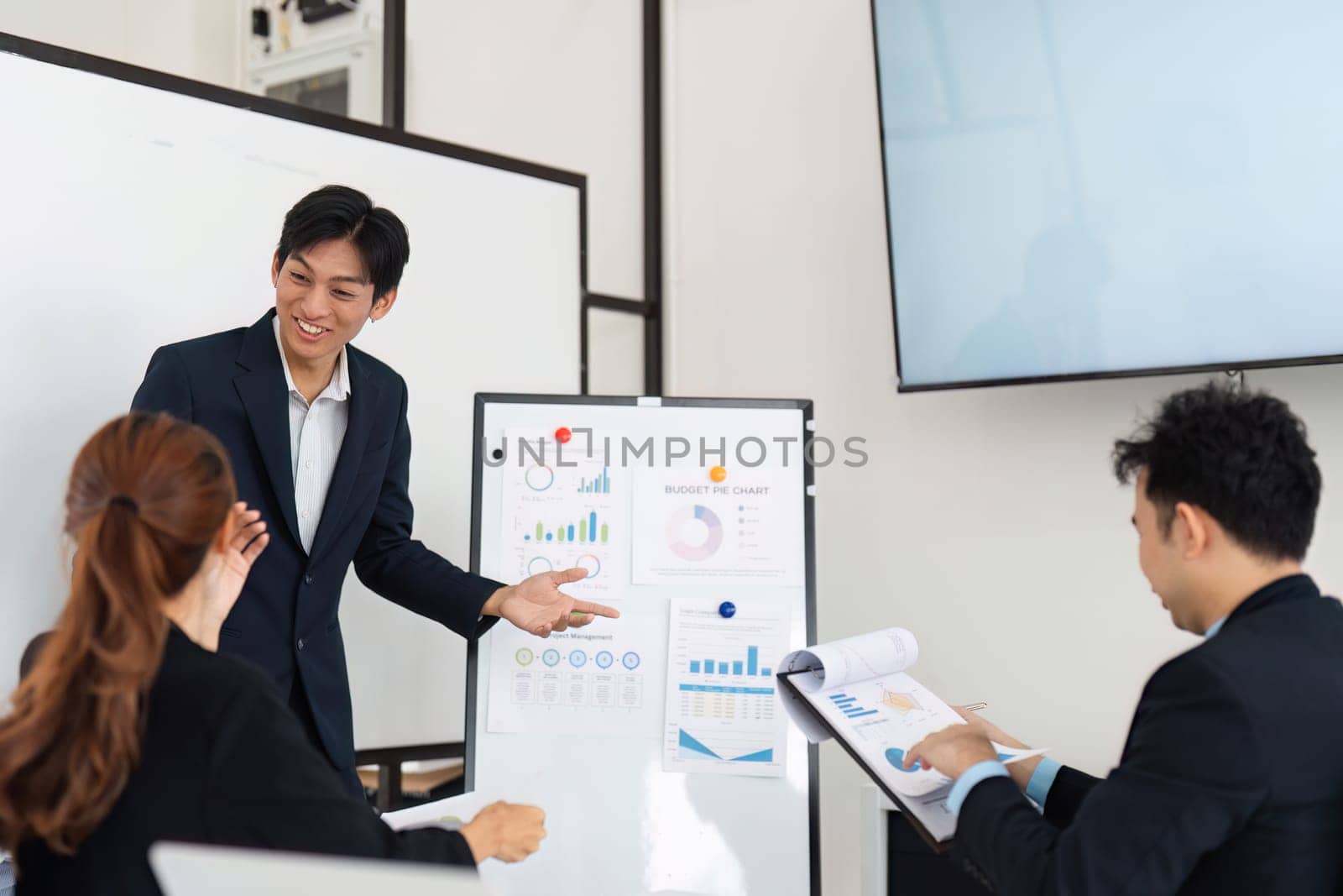 The presenter is showcasing project management statistics, while team members discuss insights and provide feedback. This collaborative effort highlights the importance of data in decision-making.
