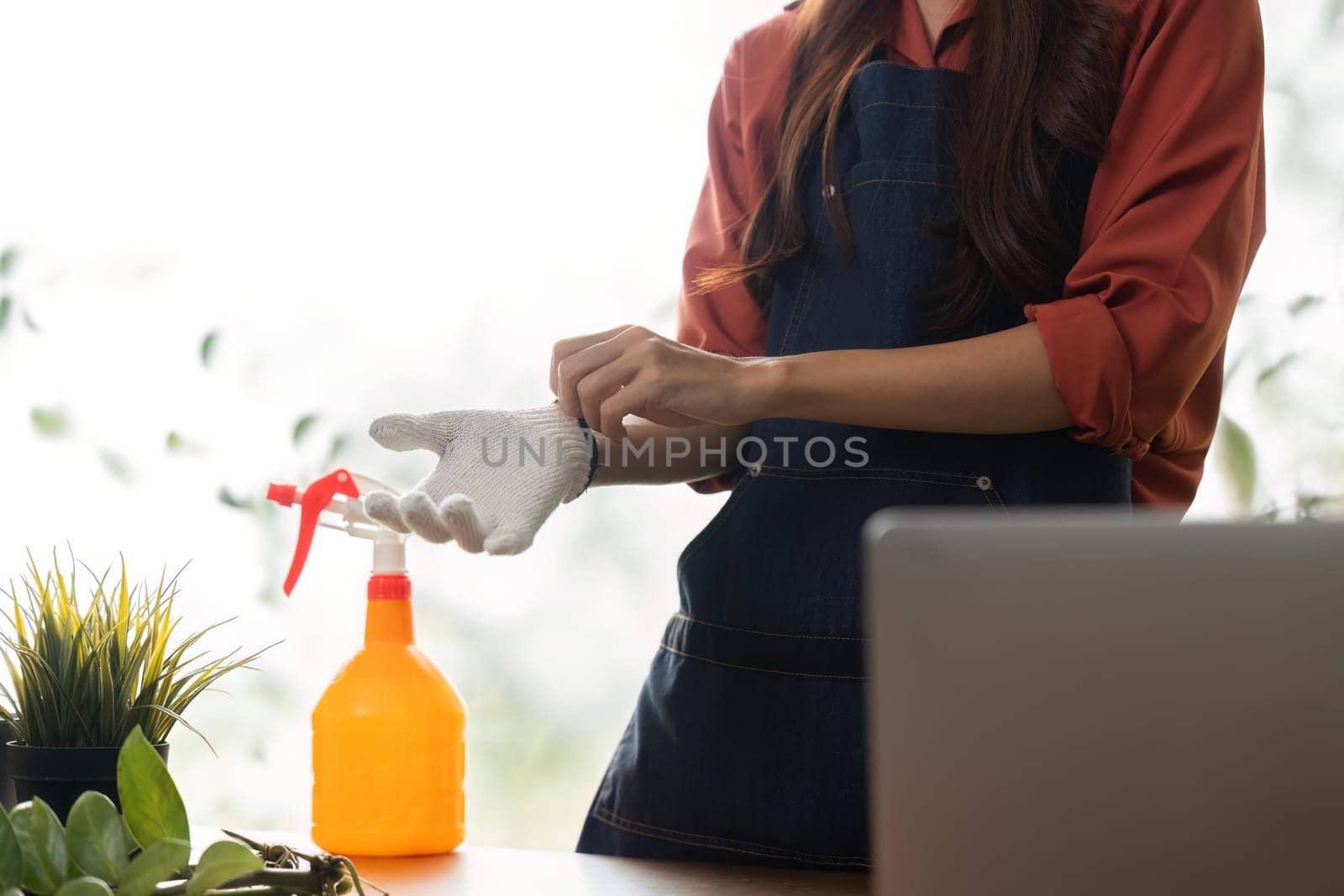 A responsible gardener gets ready to protect her plants, emphasizing the importance of proper preparation in sustainable gardening.