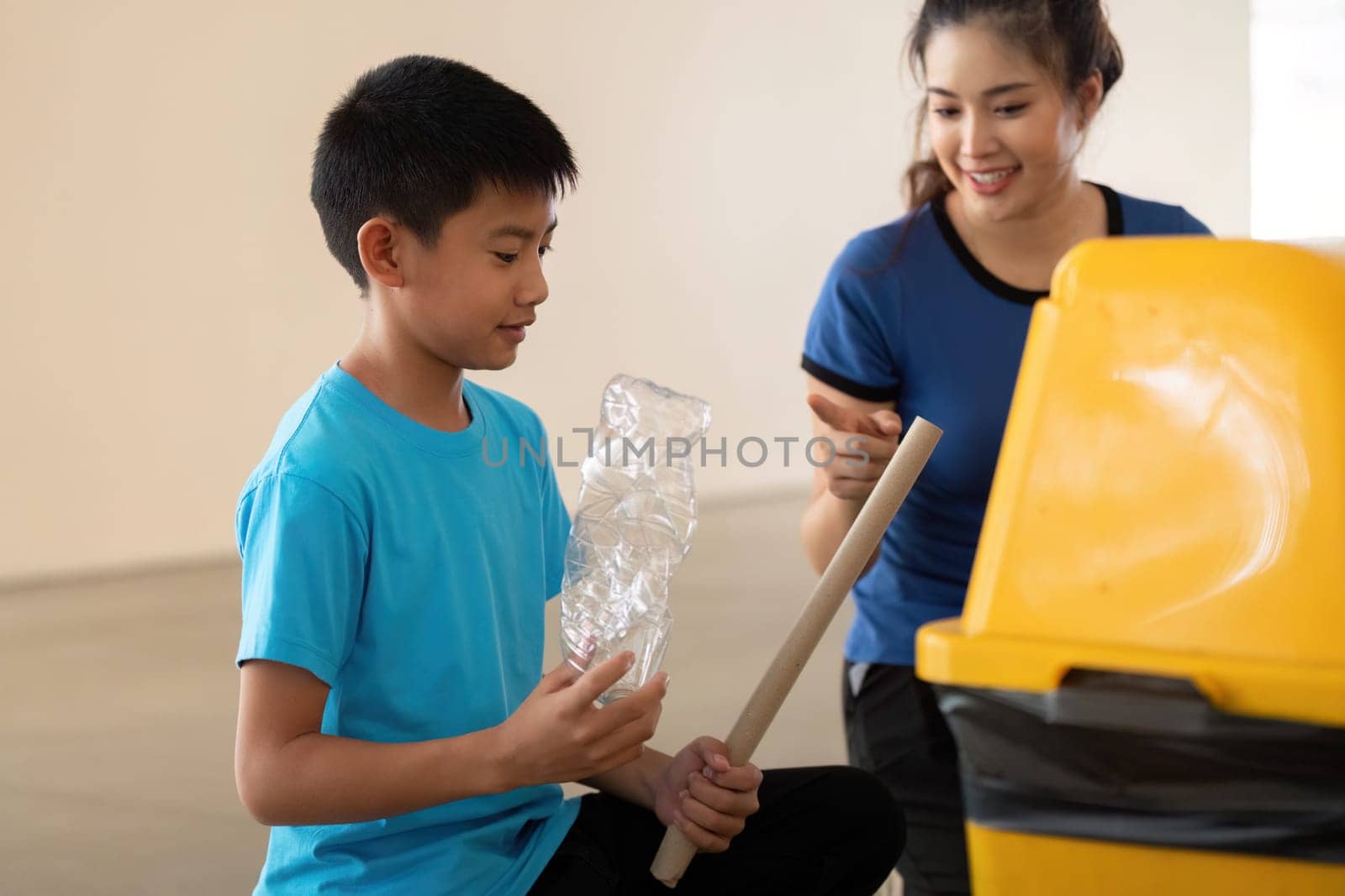 In a community initiative, a young boy discovers the importance of recycling, assisted by a woman who guides him in proper disposal techniques.