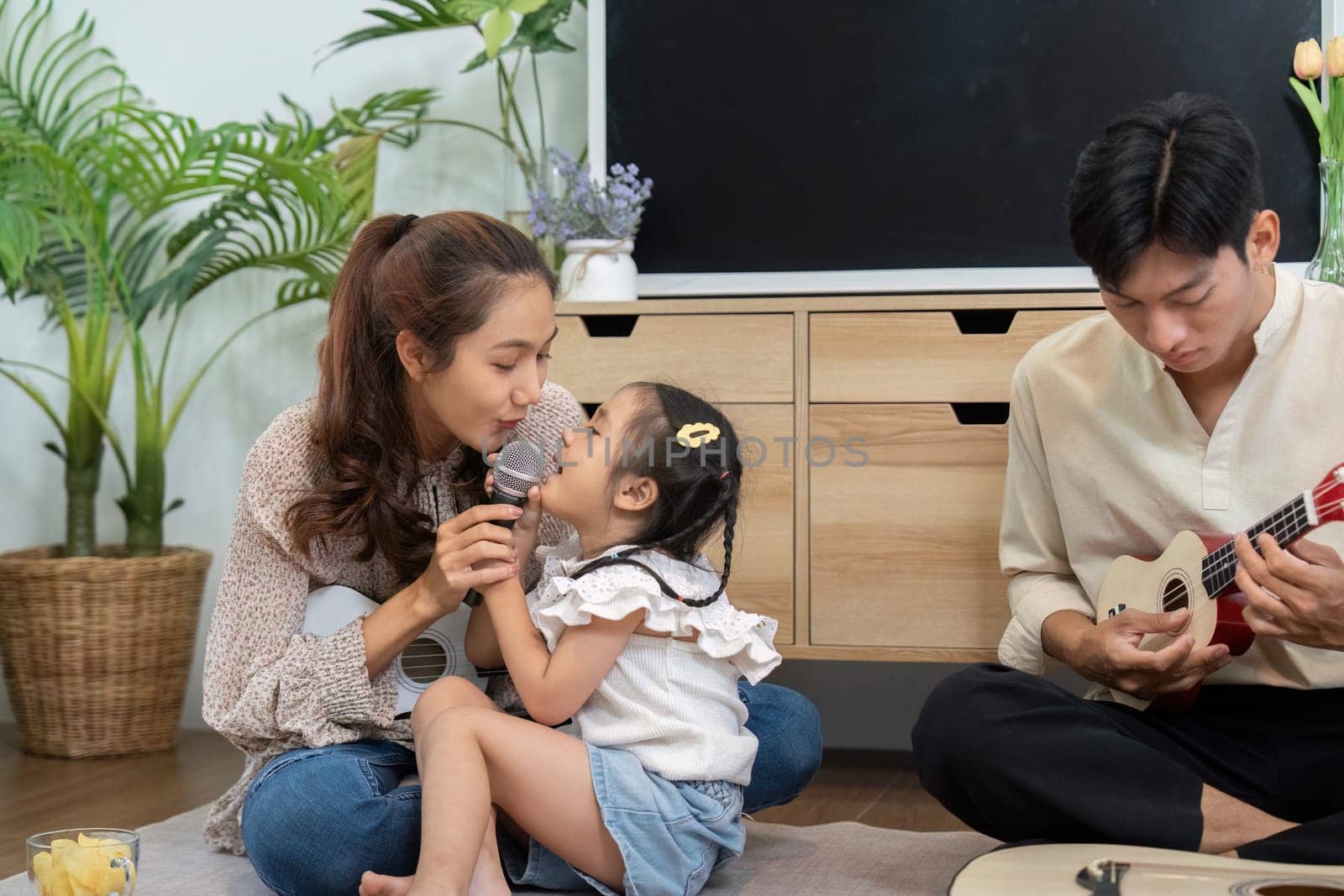 A loving interaction as a mother and daughter share a singing moment, reinforcing their bond through fun and creative expressiveness at home.