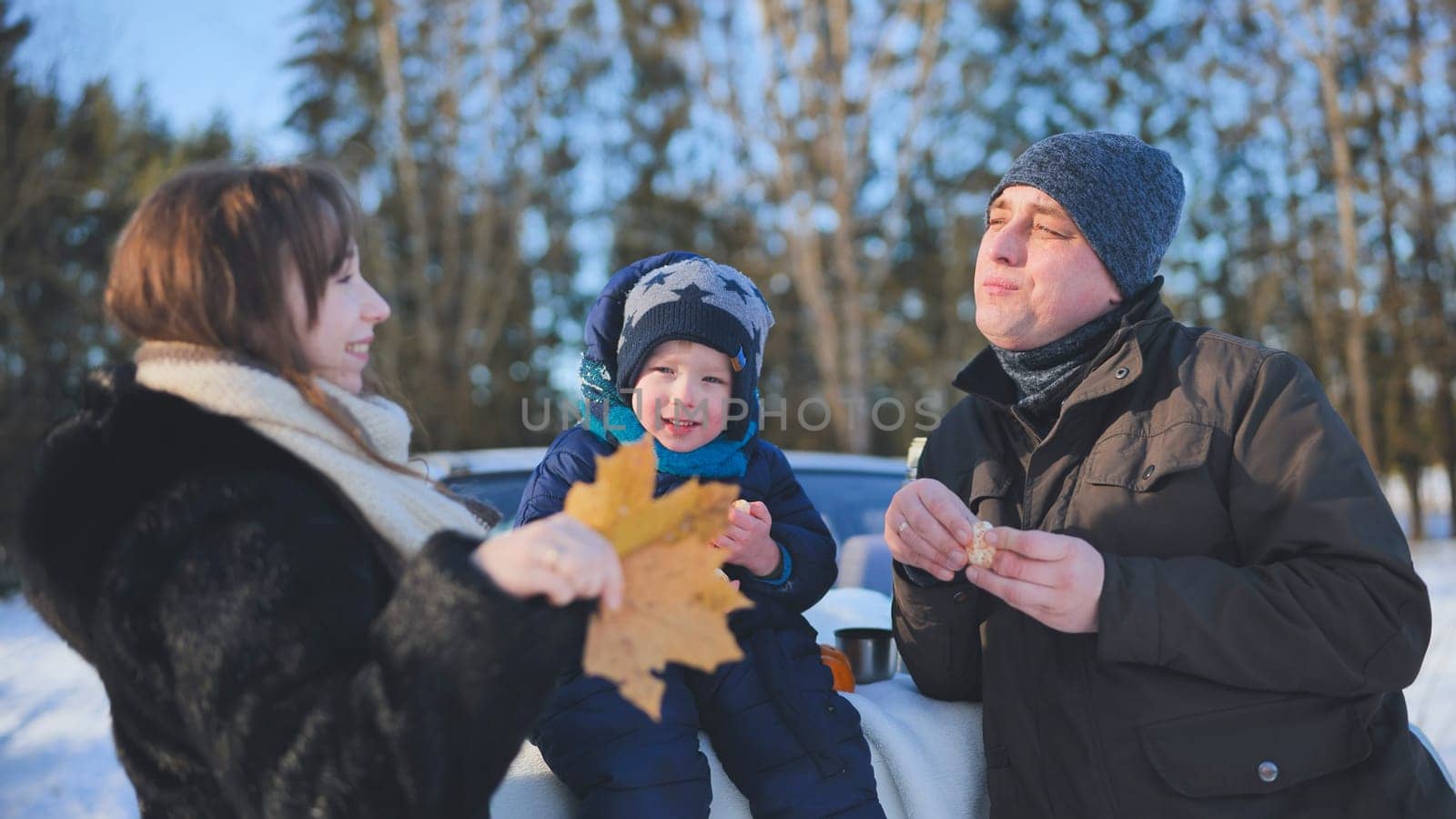 Happy family enjoying a winter picnic in a snowy forest, sharing laughter and creating joyful memories together in nature's beauty