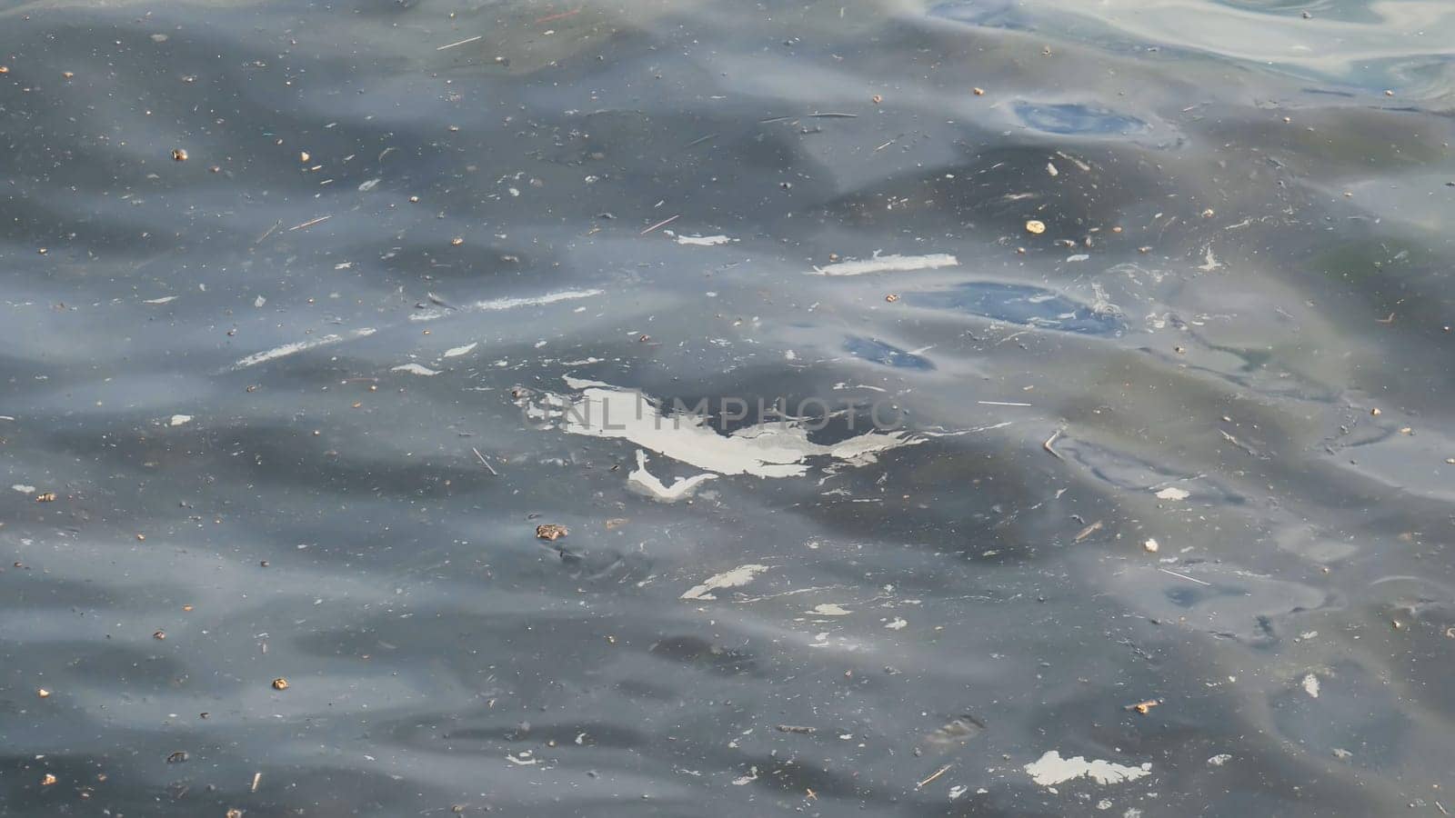 Contaminated water surface covered with plastic waste, garbage, and debris, revealing ecological degradation and pollution impact