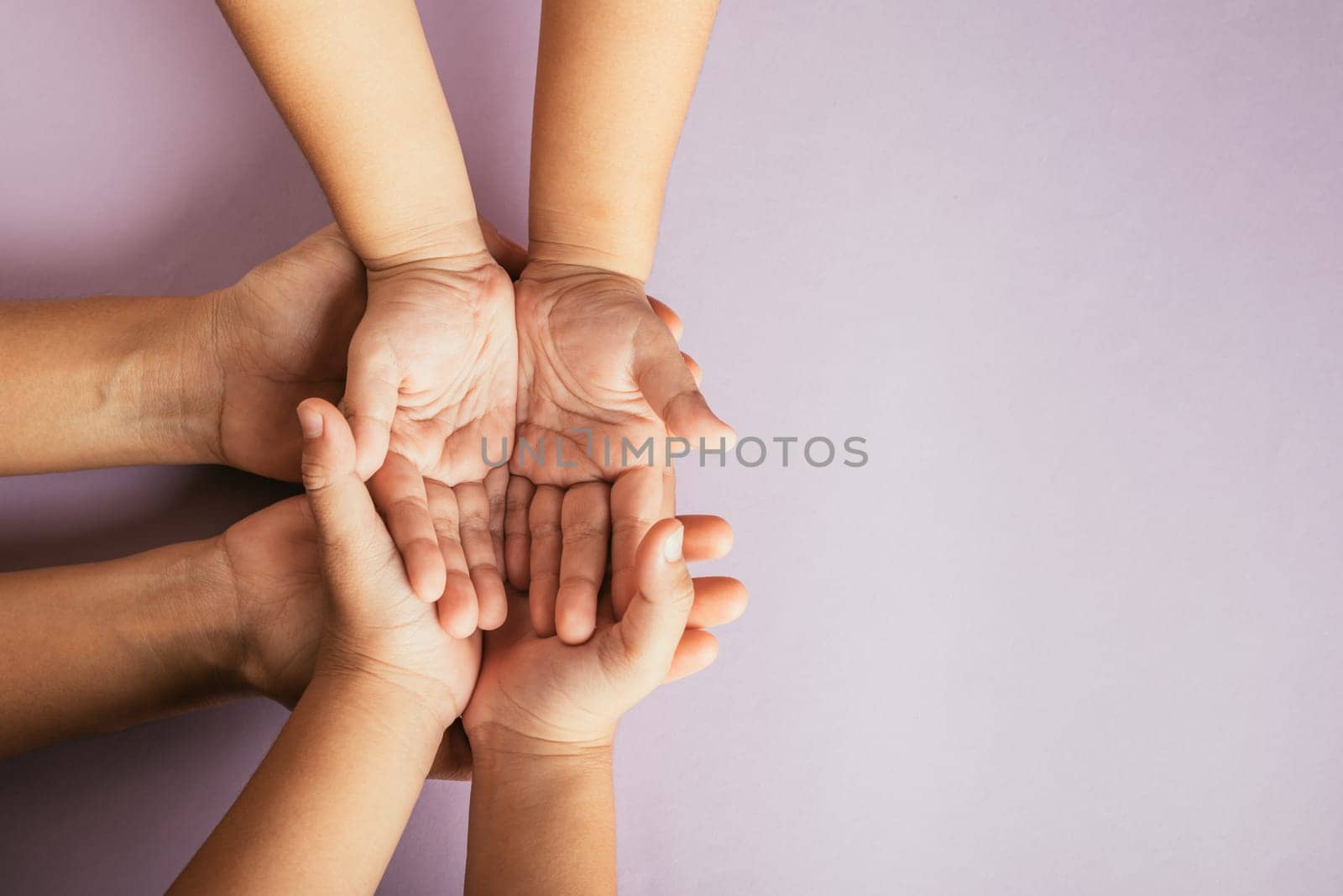 Celebrating Family Day, Top view of parents and kid holding empty hands on color background. A symbol of togetherness support and generational connection.