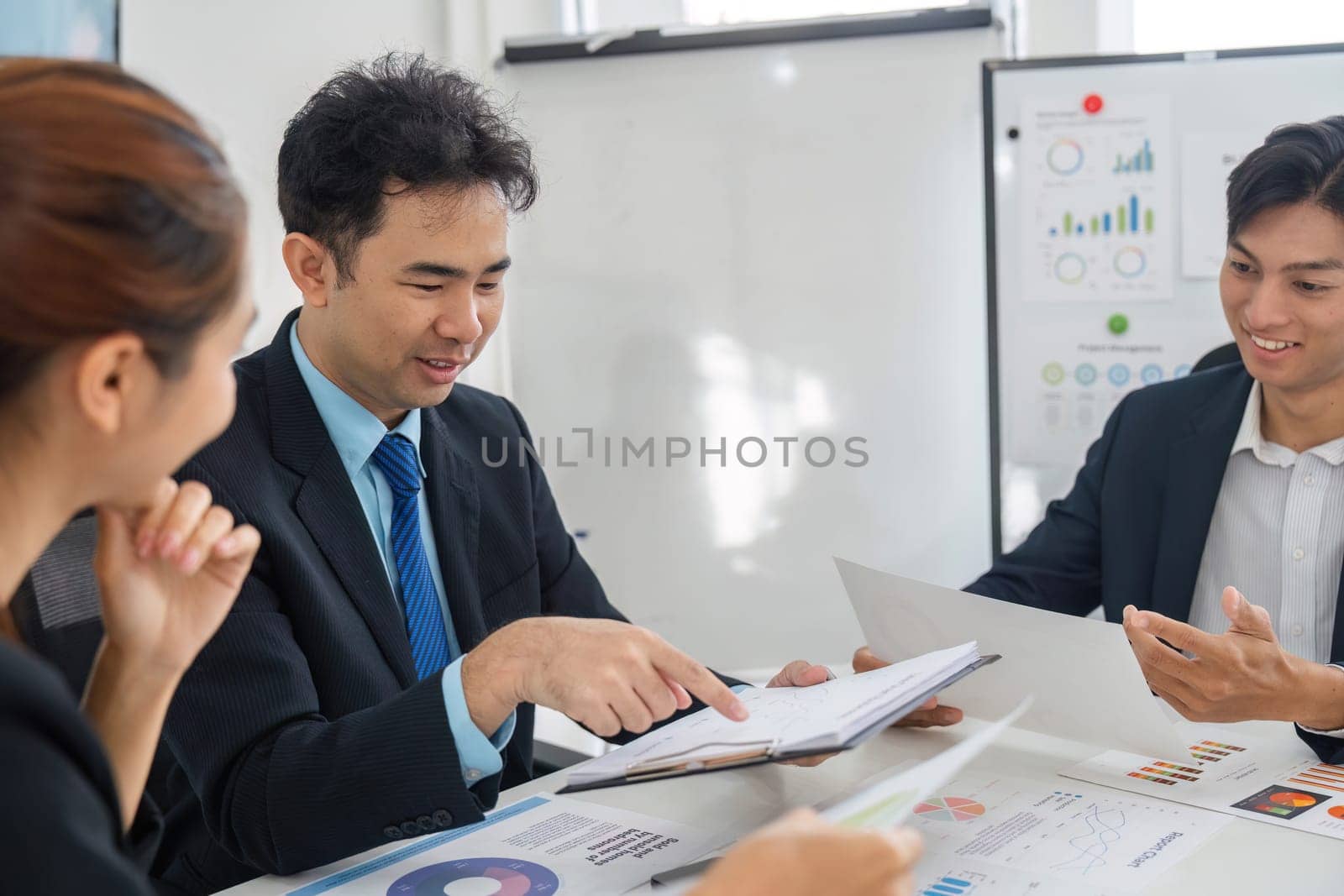 Team members work together to evaluate performance metrics, sharing insights and strategies in a dynamic business meeting.