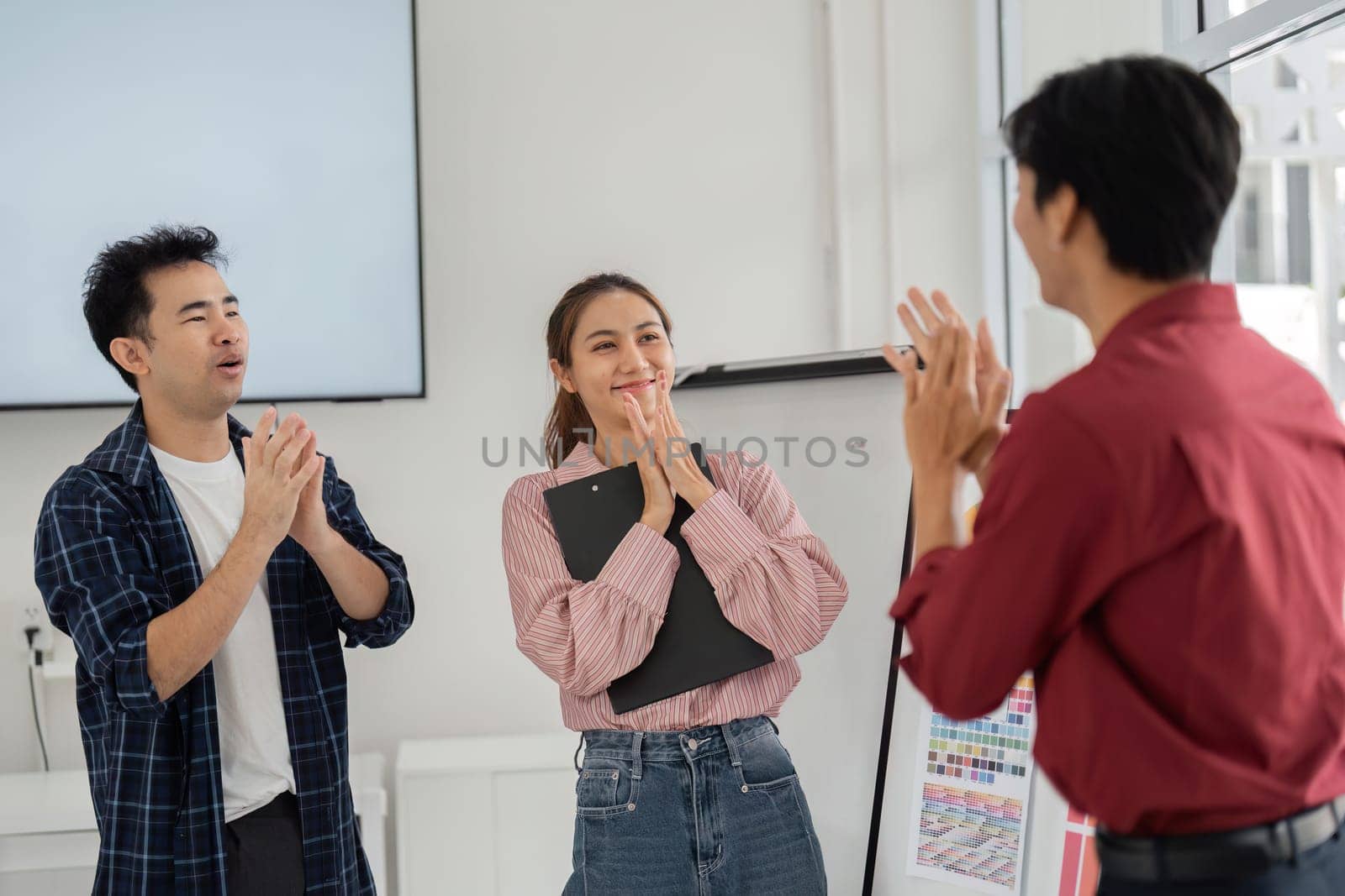 In a moment of genuine connection, team members express gratitude and joy after achieving a breakthrough in their creative project during a friendly meeting.