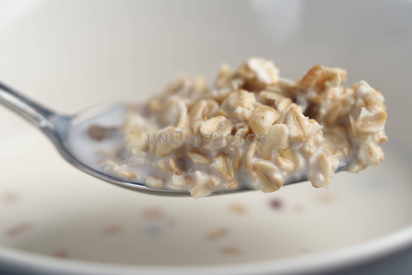 Close-up of a spoonful of oatmeal featuring creamy texture and grains.