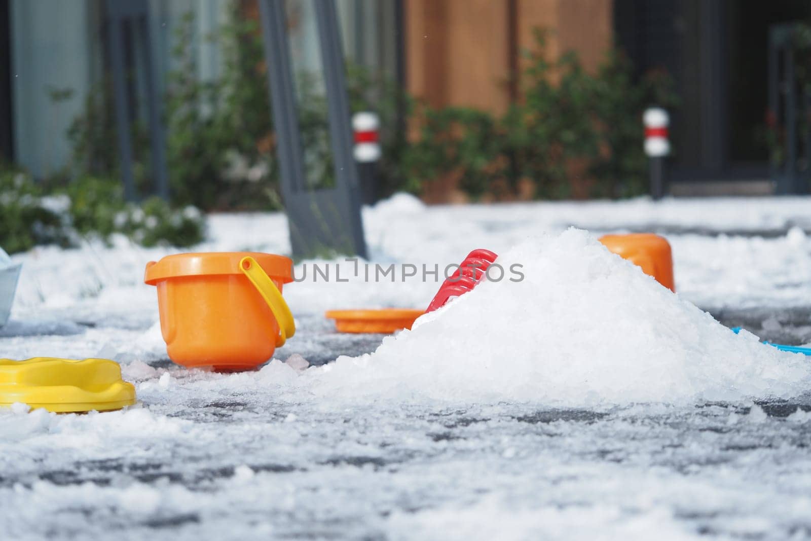 Brightly colored buckets sit in the snow, creating a playful winter setting.