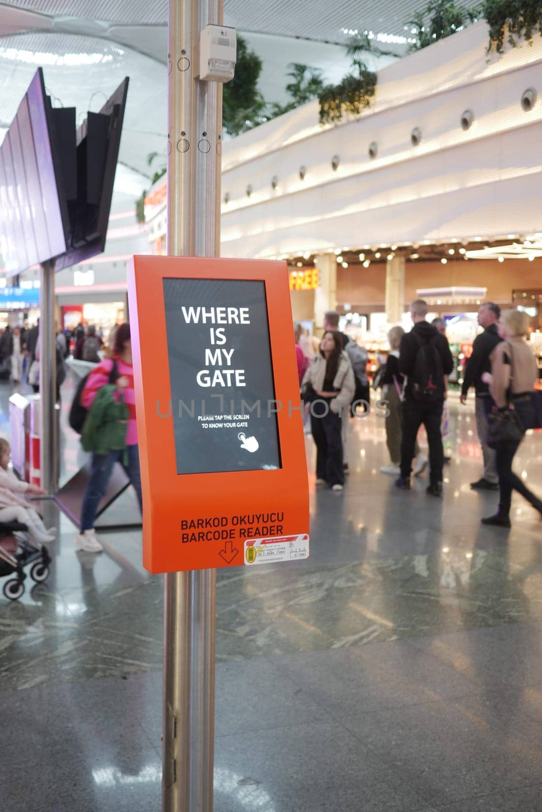 People crowd around an information kiosk searching for their flight gates.