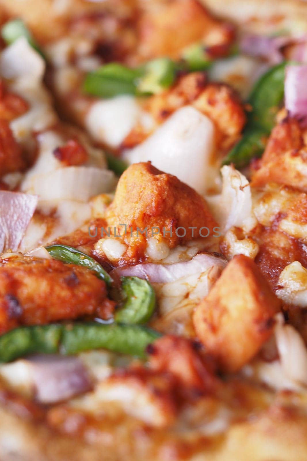 Delicious pizza with fresh toppings being prepared in a vibrant kitchen.