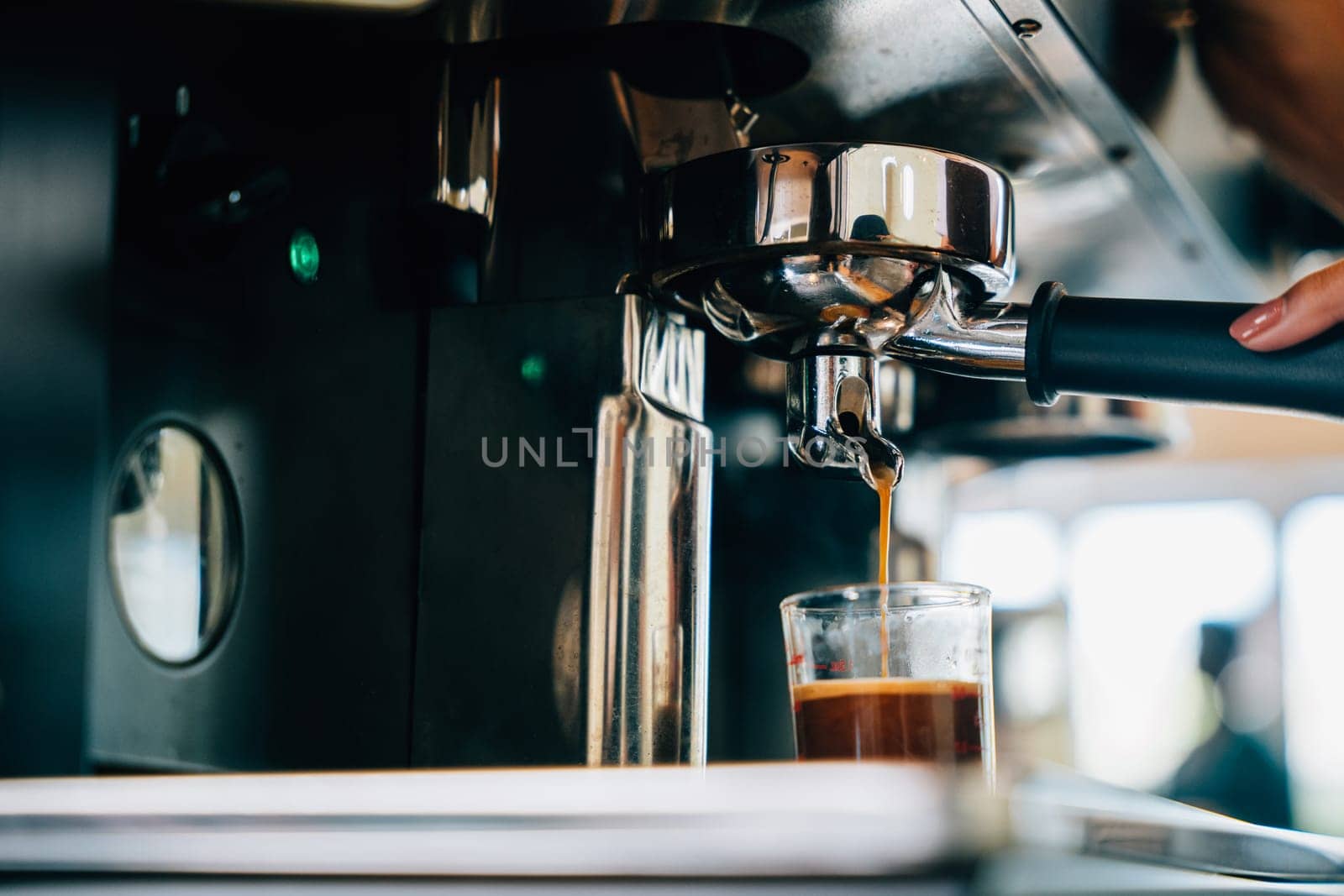 At cafe shop coffee pours from espresso machine. Modern technology showcased with liquid flowing into glasses. Smooth service transparent cups displaying the coffee making process.