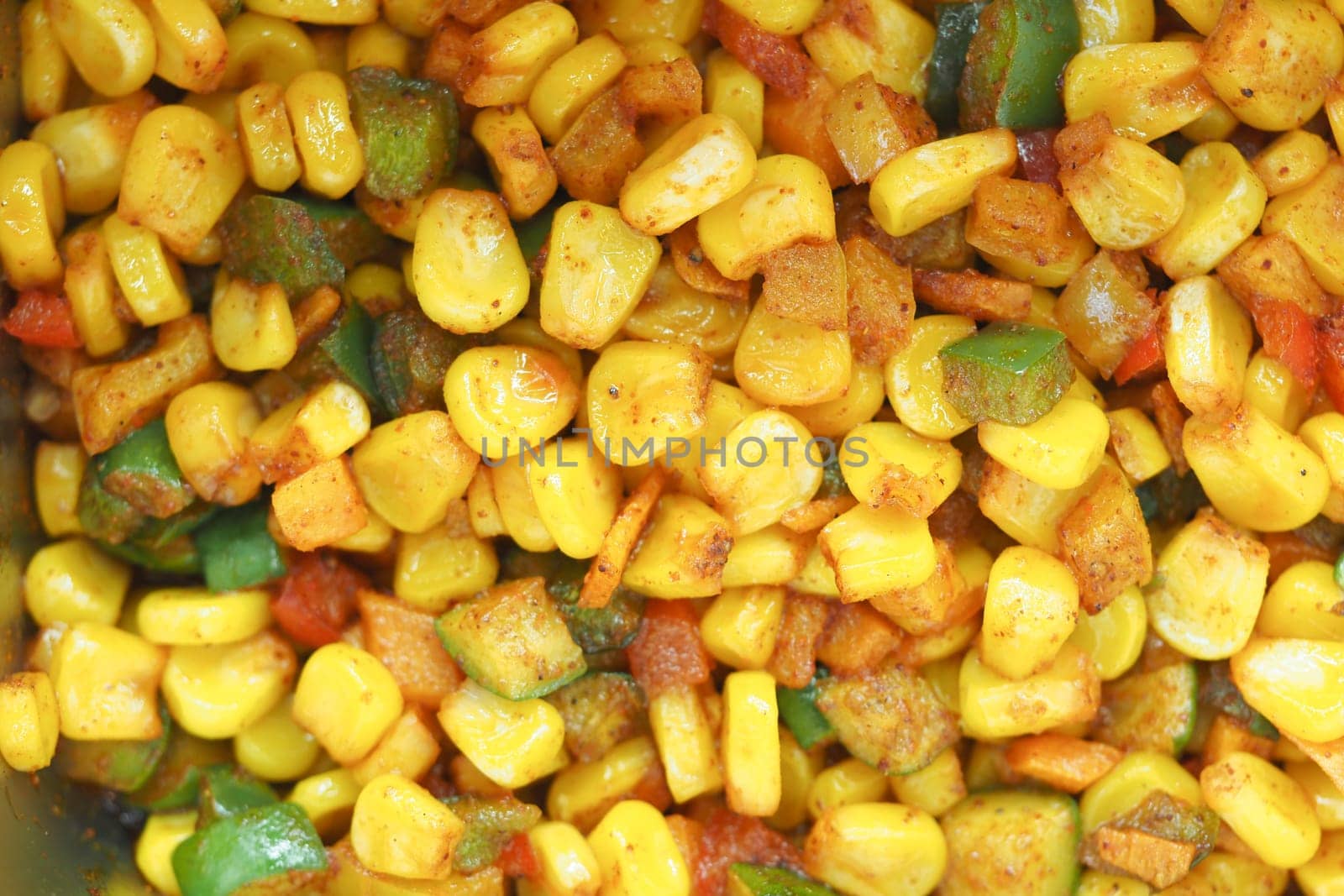 Mixed corn and diced bell peppers cooked with spices in a bowl.