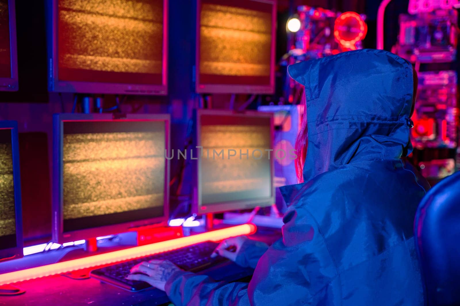 Woman hacker wear hood sit front computer typing on keyboard hacking servers in neon light, Gamer woman streaming game online dark room, Female hacker breaks into data center, Blockchain cyberattack