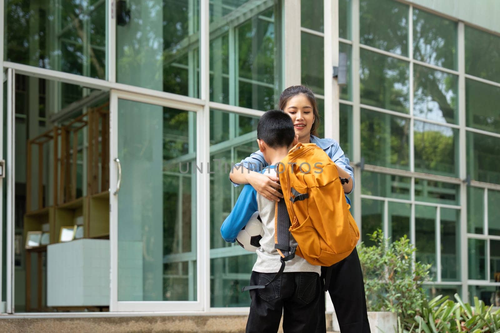 Emphasizing the importance of family support, a mother assists her son before school, showcasing a loving parental role in education.