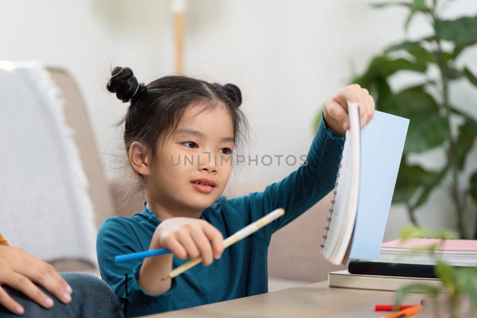 In a cozy home setting, a girl shares her artwork and writings with her caregiver, showcasing her efforts and creativity.