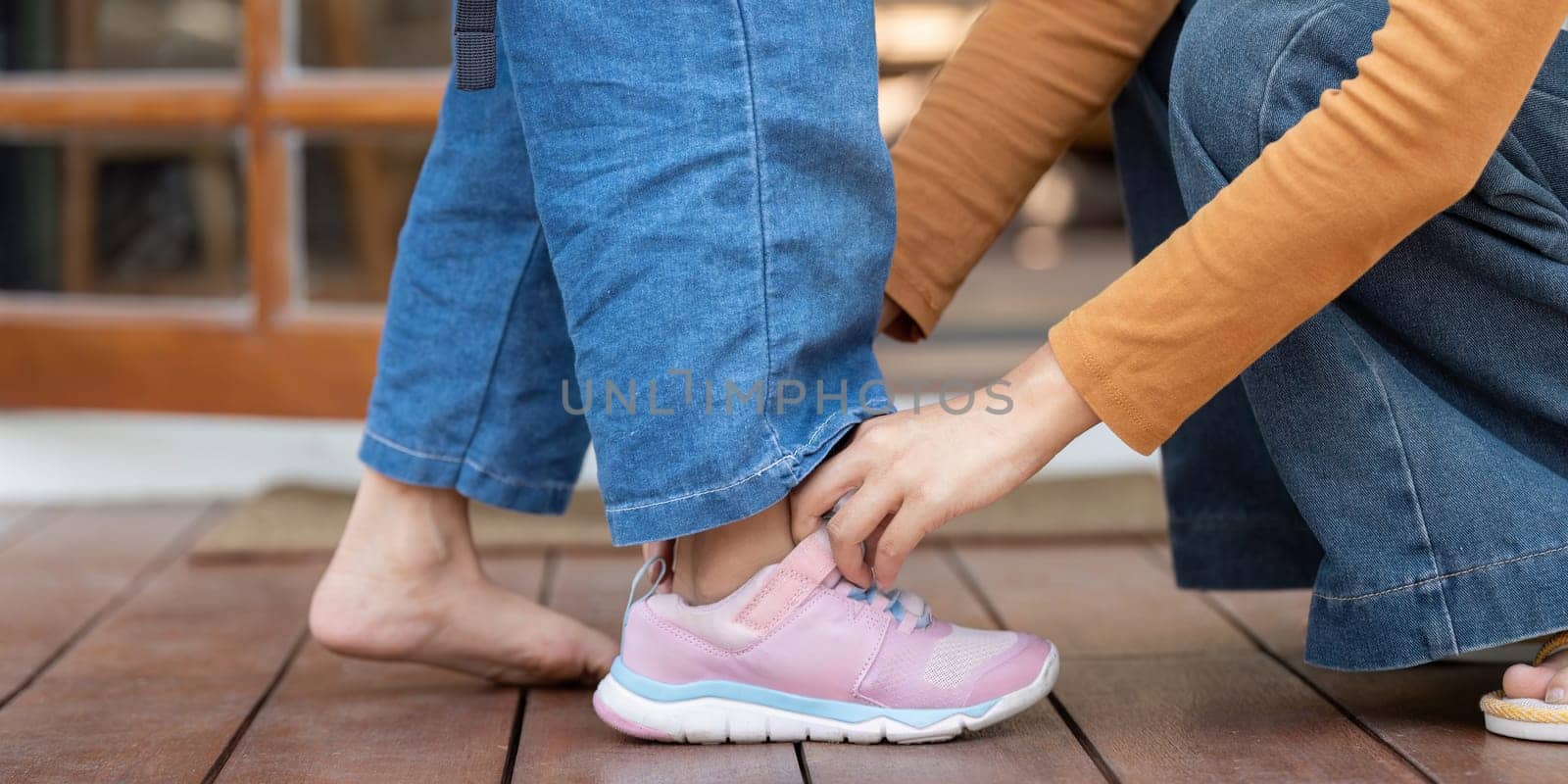 A caring parent assists their child in putting on shoes, emphasizing the importance of preparation for school. This moment showcases parental support and readiness.