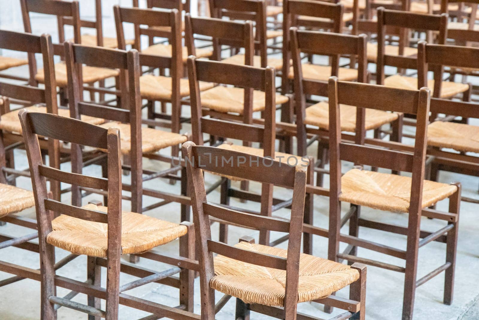Rows of empty old wooden seats or chairs in the church, theatre or music concert, abstract pattern.