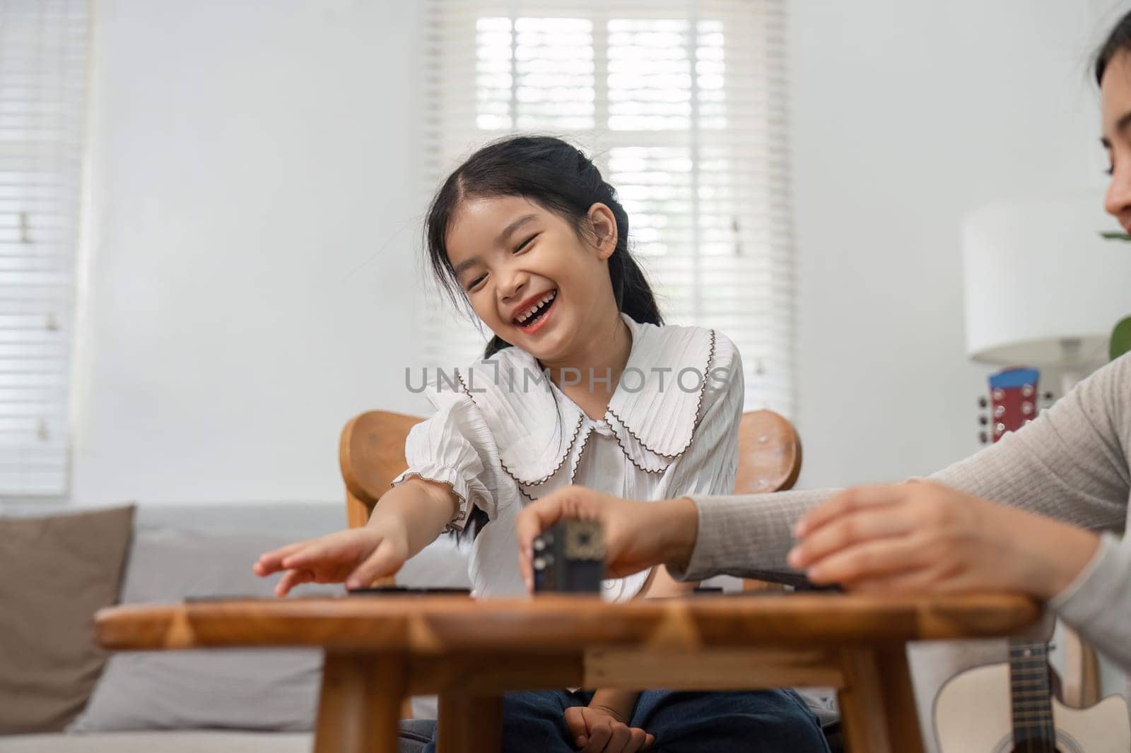 Amid laughter and joy, a girl shares a playful interaction with her mother, emphasizing the importance of family time through games.