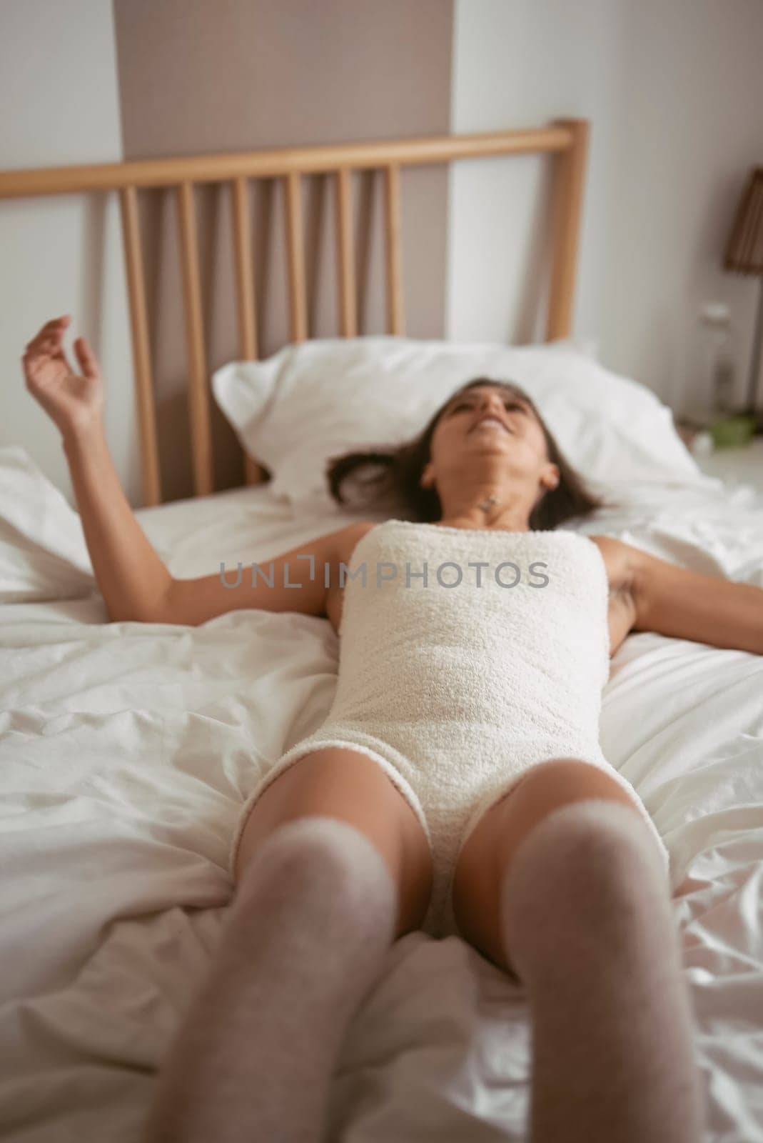 A serene moment captured in warm lighting, showcasing relaxation and comfort on a cozy, inviting bed