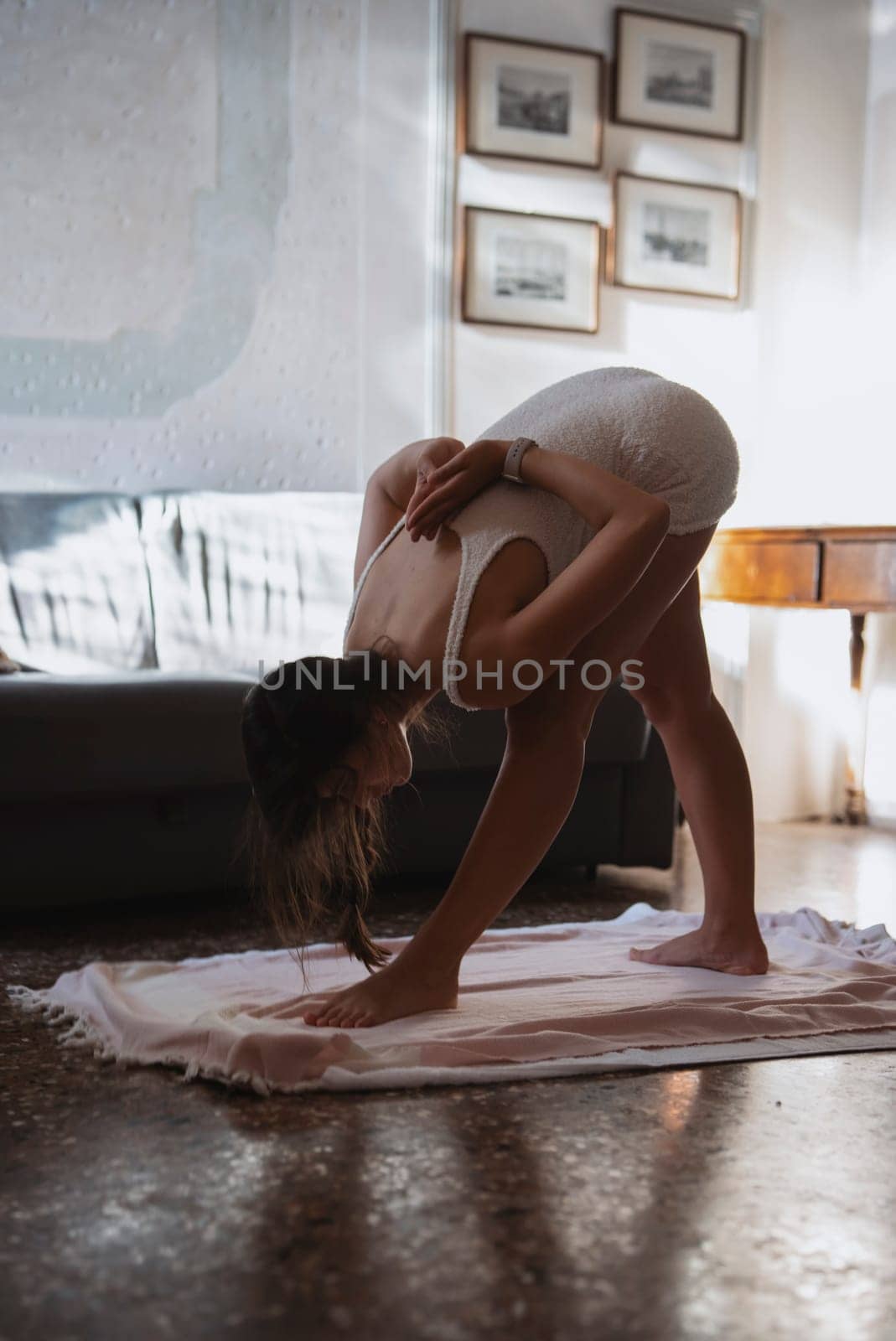 A person practices yoga indoors, demonstrating flexibility and a serene sense of calm in a peaceful moment