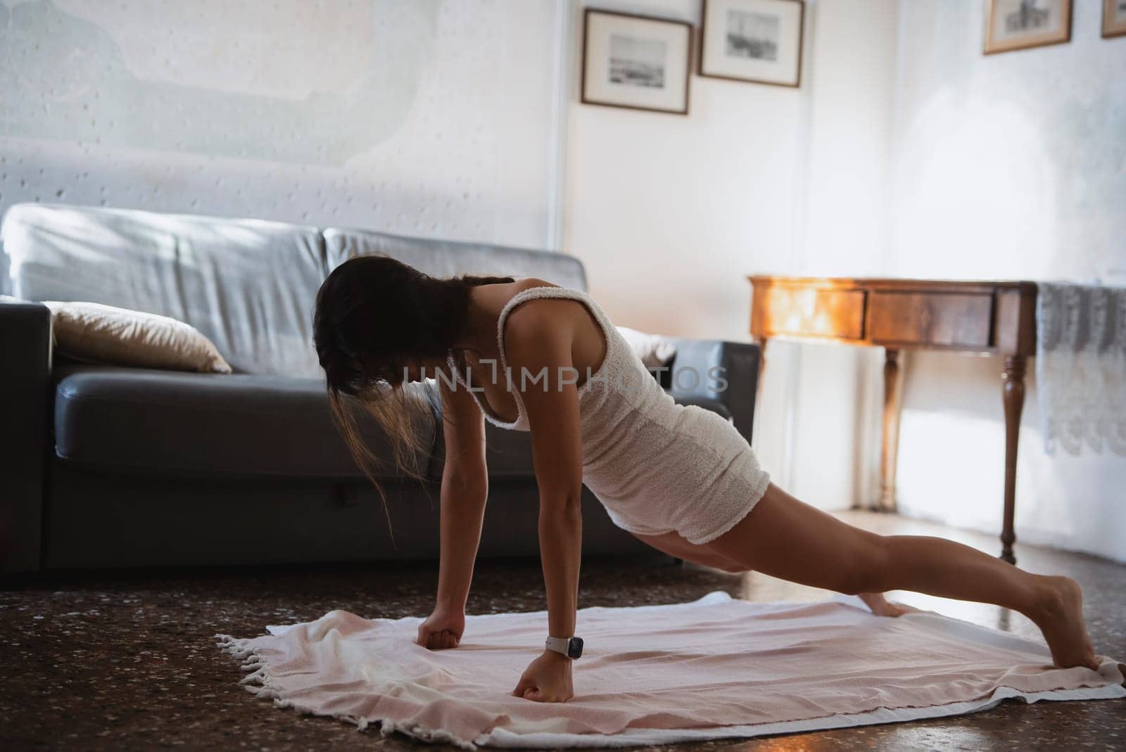 A woman engages in pushups at her residence, showcasing her unwavering commitment to fitness and overall health