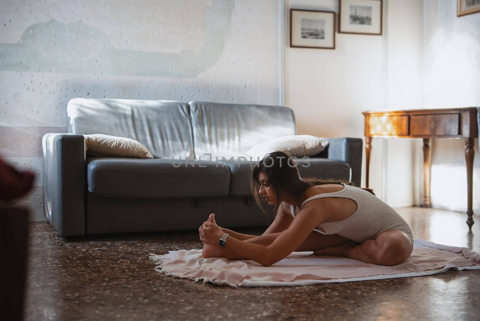 A woman stretches in her serene living room, highlighting wellness and mindfulness, showcasing inner peace
