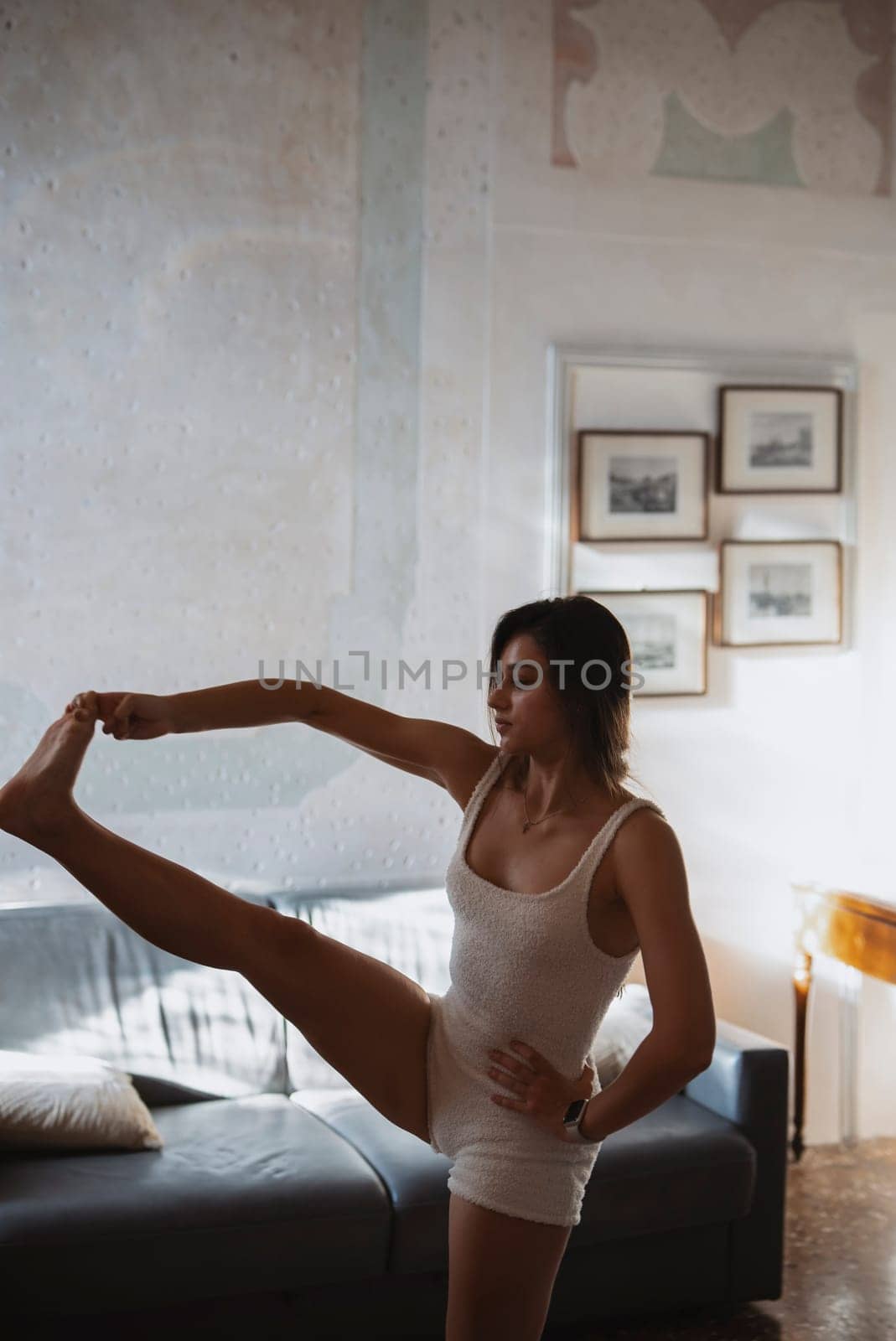 An exceptionally poised athlete gracefully demonstrates remarkable flexibility and strength in a contemporary setting