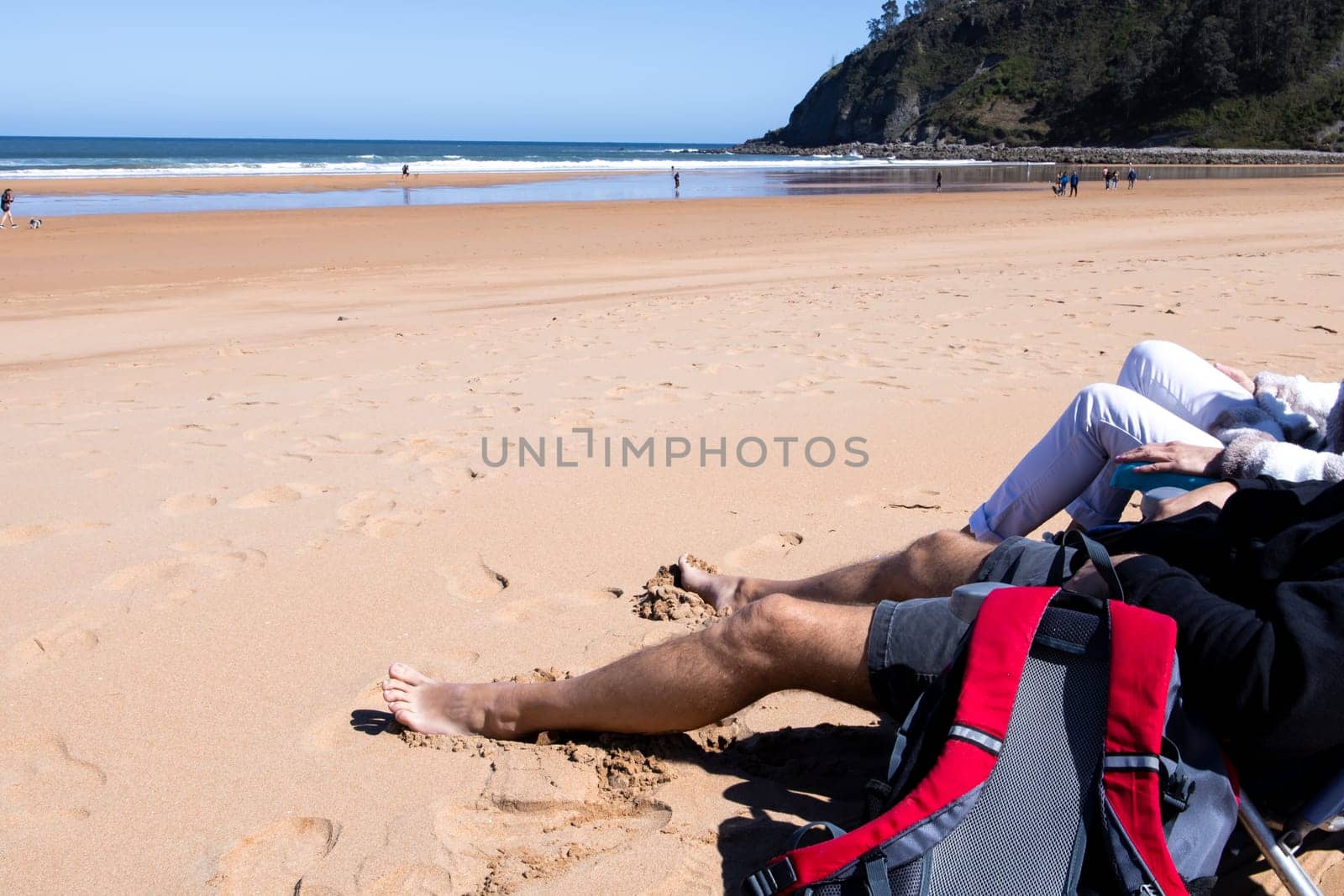 Sandy beach relaxation with young couple enjoying sunny day at seaside.