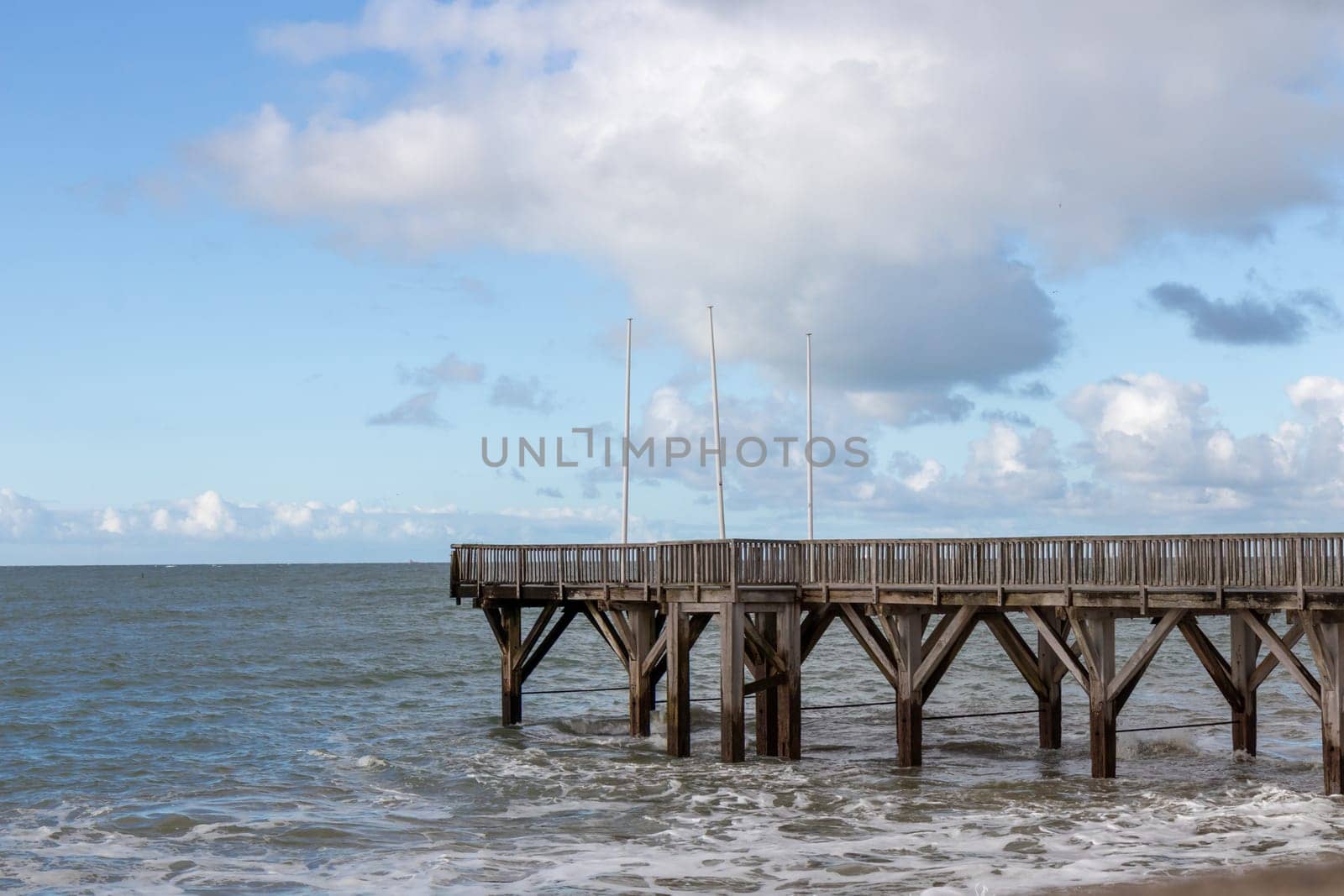 Sainte-Adresse, France - February 27, 2025: A wooden pontoon stretches into the English Channel from Sainte-Adresse, near Le Havre, under a cool February sky along the coast of Seine-Maritime, France