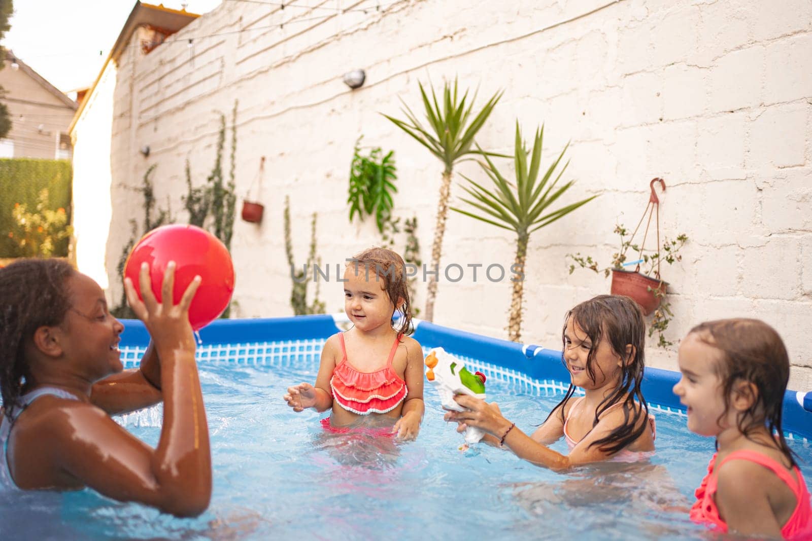 Four kids splash and play together in a vibrant outdoor pool.