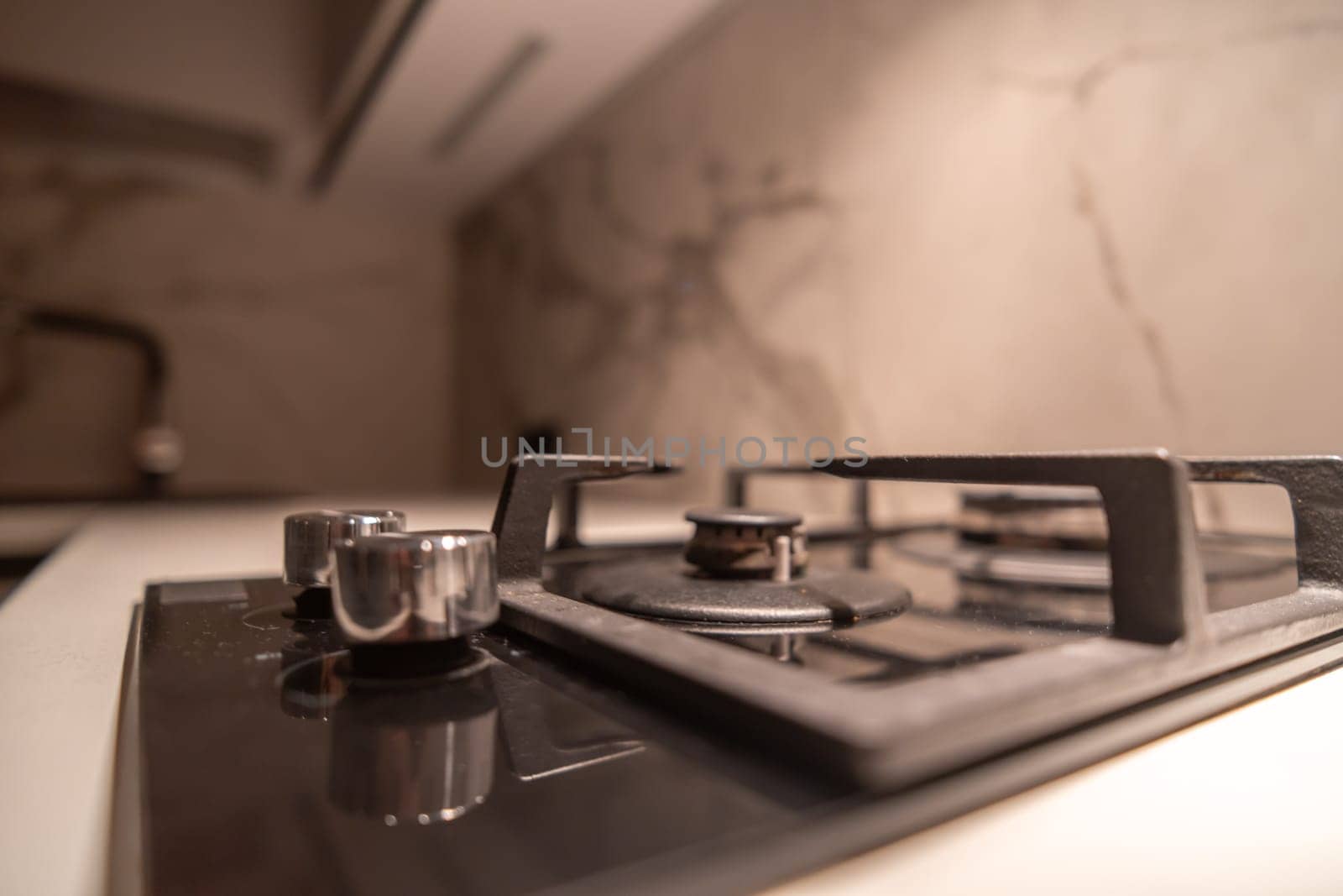 Close-up of a modern, gas cooktop integrated into a sleek kitchen countertop. Burners and controls are visible; the surface appears clean.