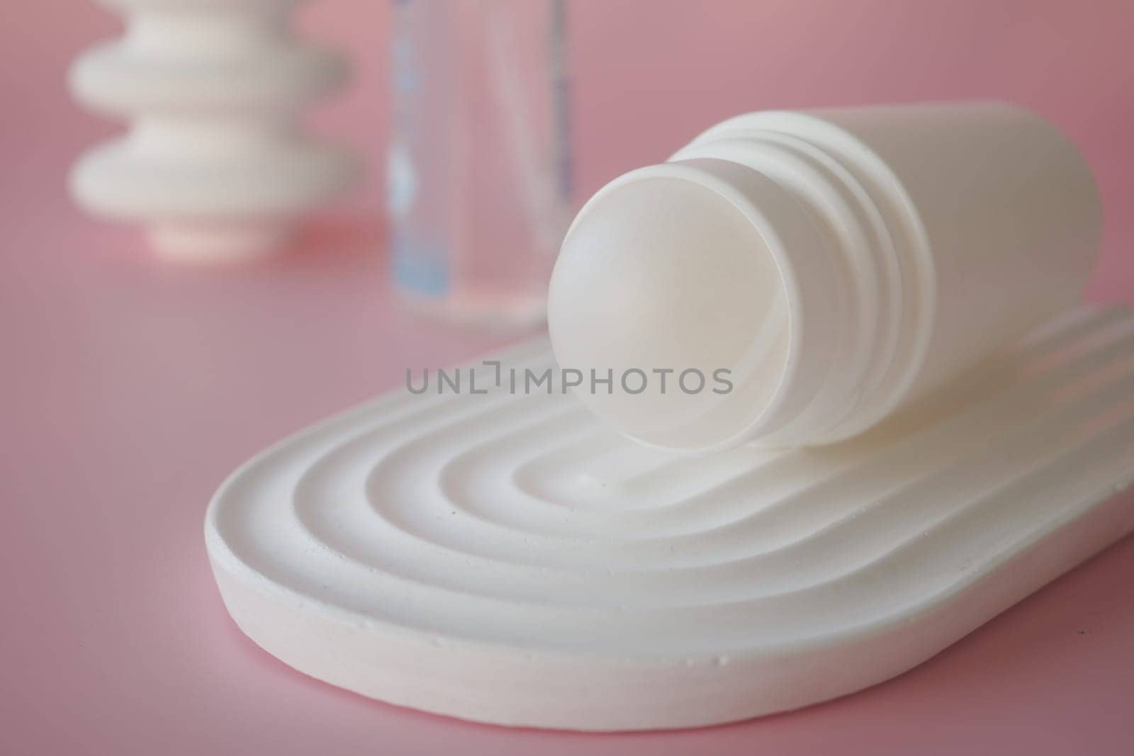 Deodorants on a textured surface with soft colors,
