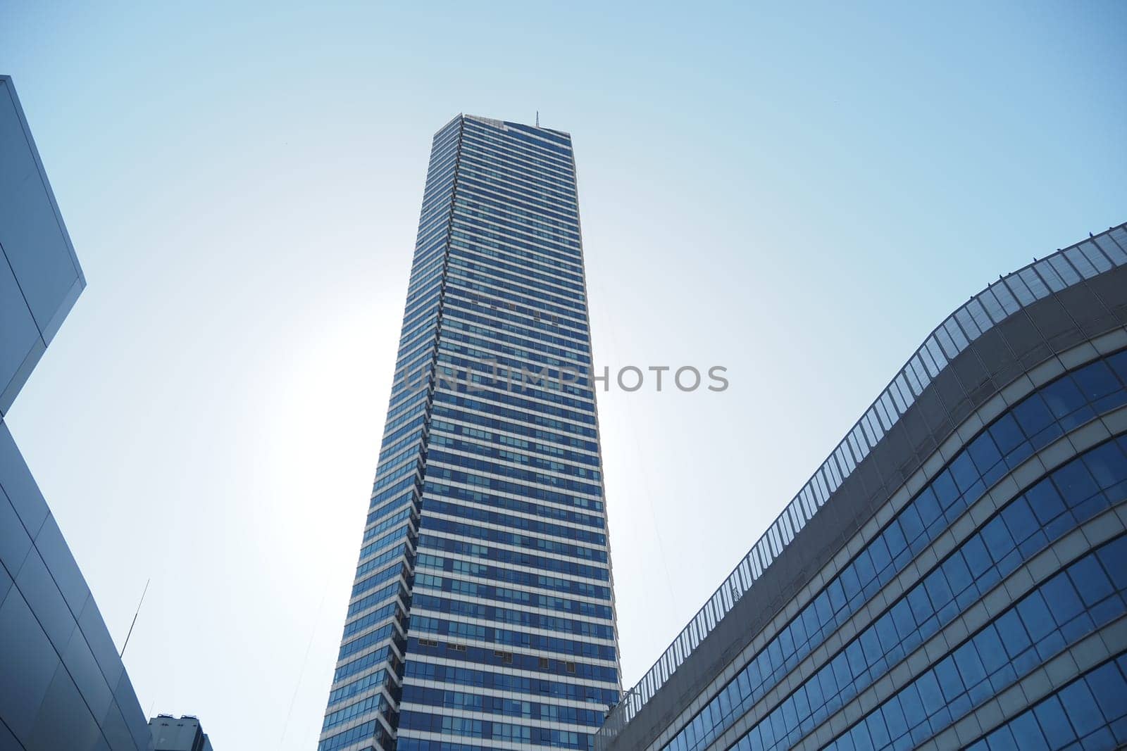 A tall skyscraper showcases modern design against a clear blue sky.