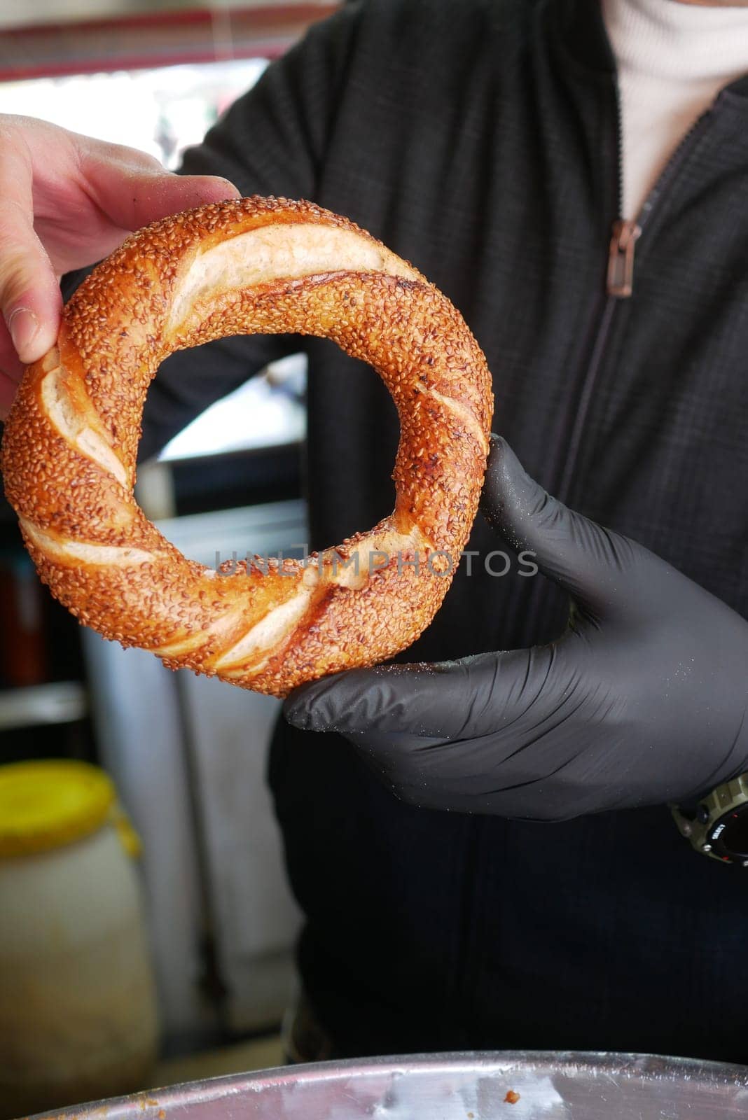 Vendor showcases traditional turkish simit at market stall.