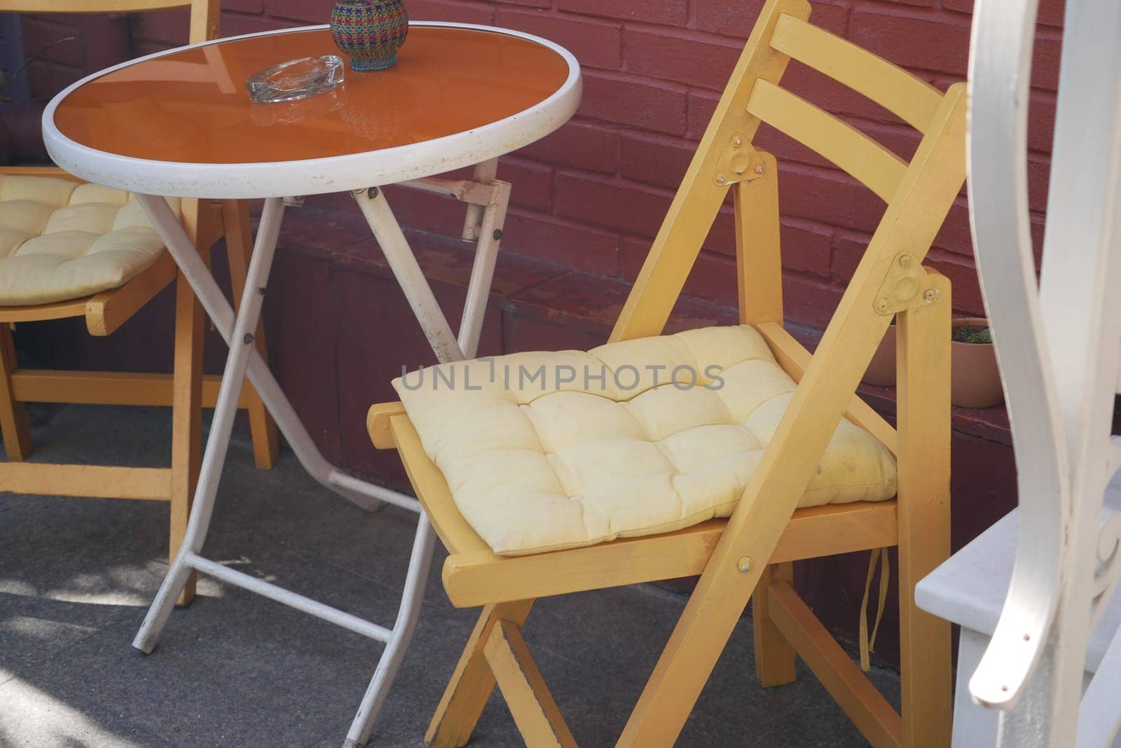 Charming cafe corner with a yellow chair and round table ready for guests.