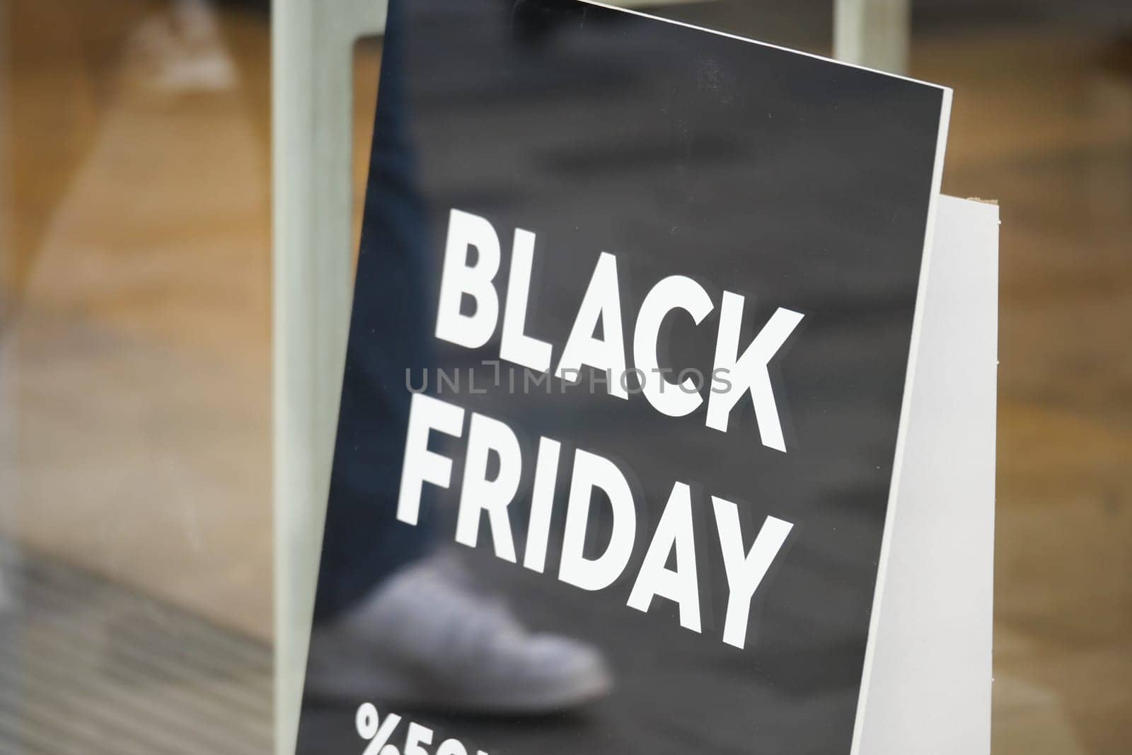 Shopping enthusiasts are drawn to a Black Friday sale sign promoting discounts.