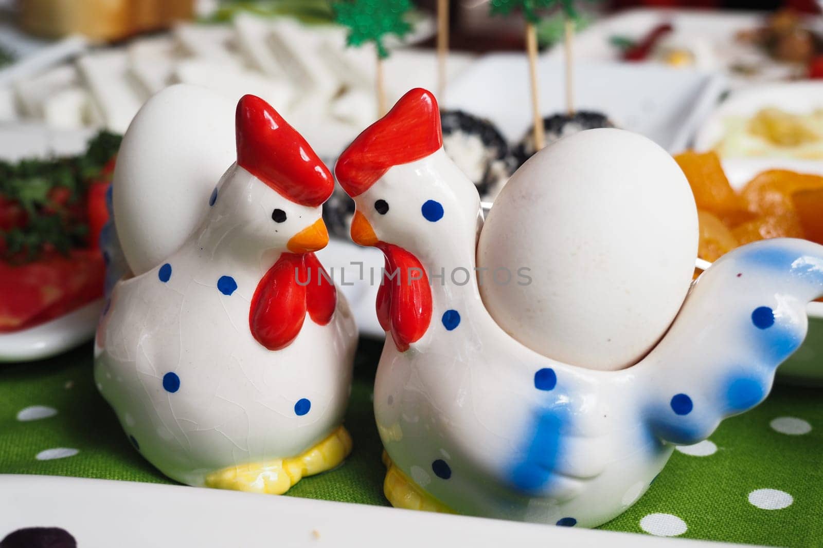 Two charming chicken shakers face each other on a colorful table setting.