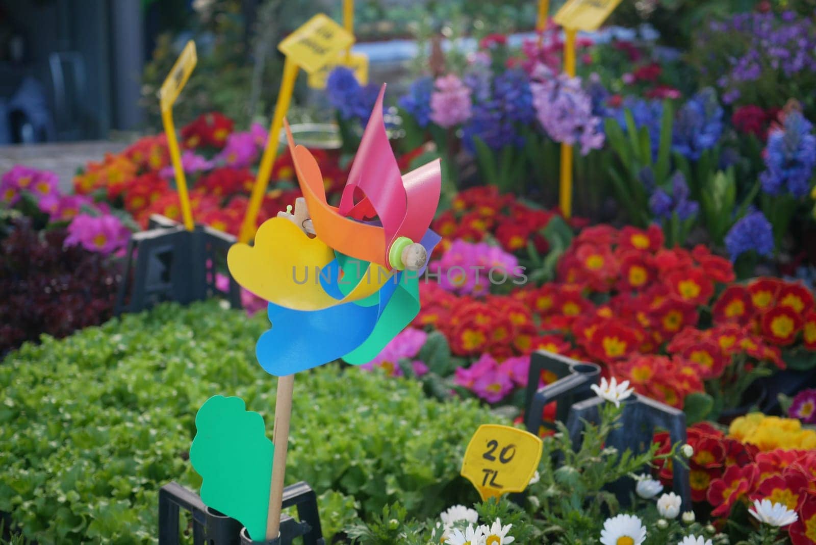 A playful windmill stands out in a flower market bursting with colors.