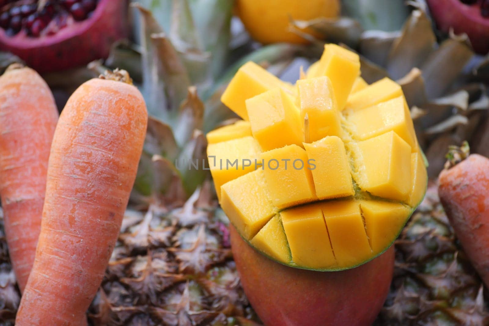 Colorful fruits including mango and carrot present on a market table.