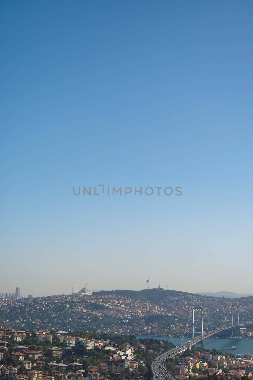 Cityscape shows a bridge and vibrant neighborhoods under blue skies.