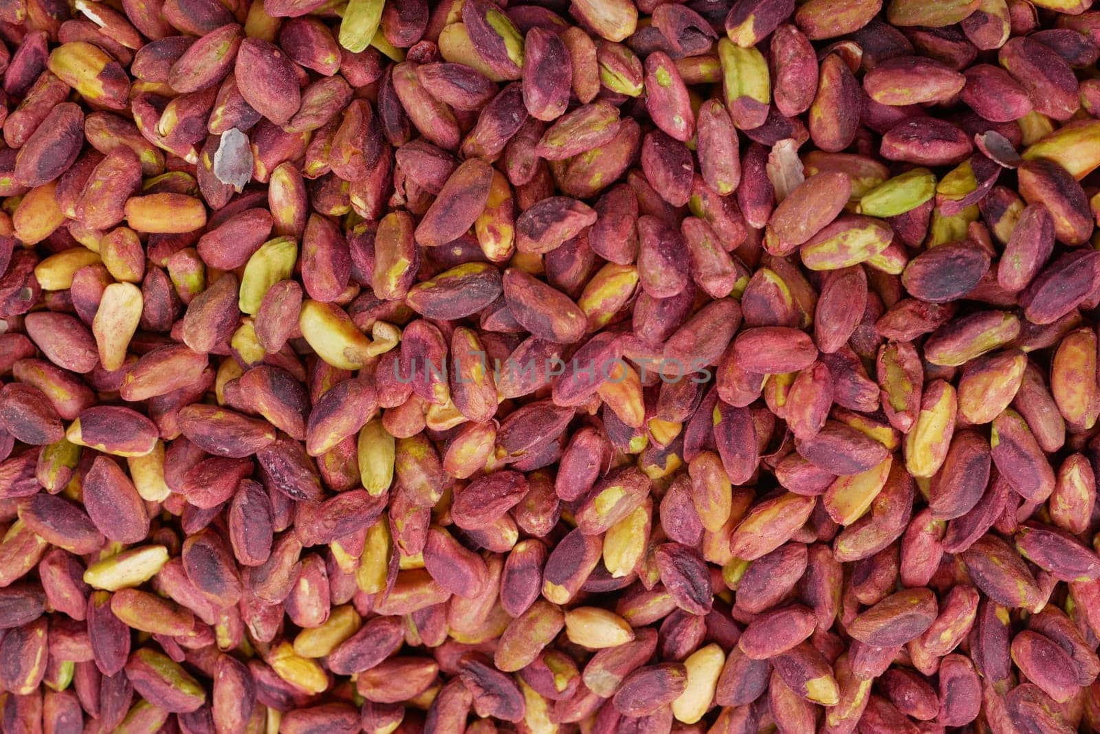 Pistachios in various shades are spread out at a market during autumn.