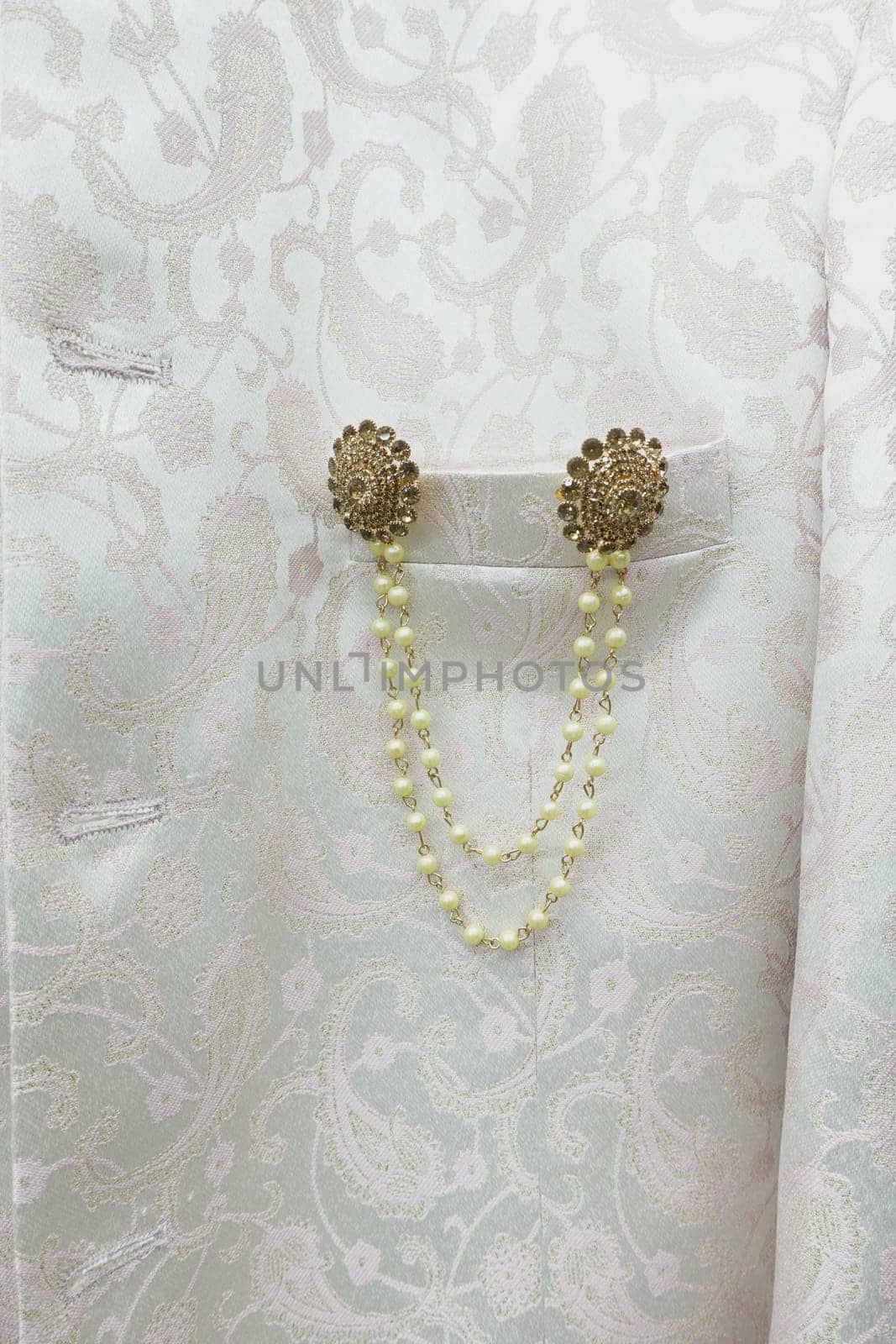 Beautiful gold and pearl embellishments on luxurious white fabric.
