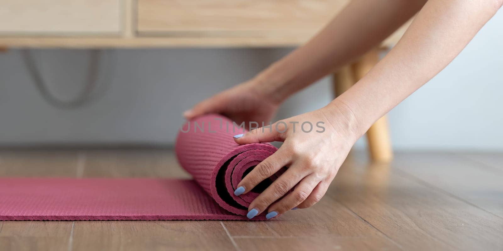 After completing her yoga session, a dedicated yogi rolls up her mat, highlighting the value of a clean environment for optimal wellness.