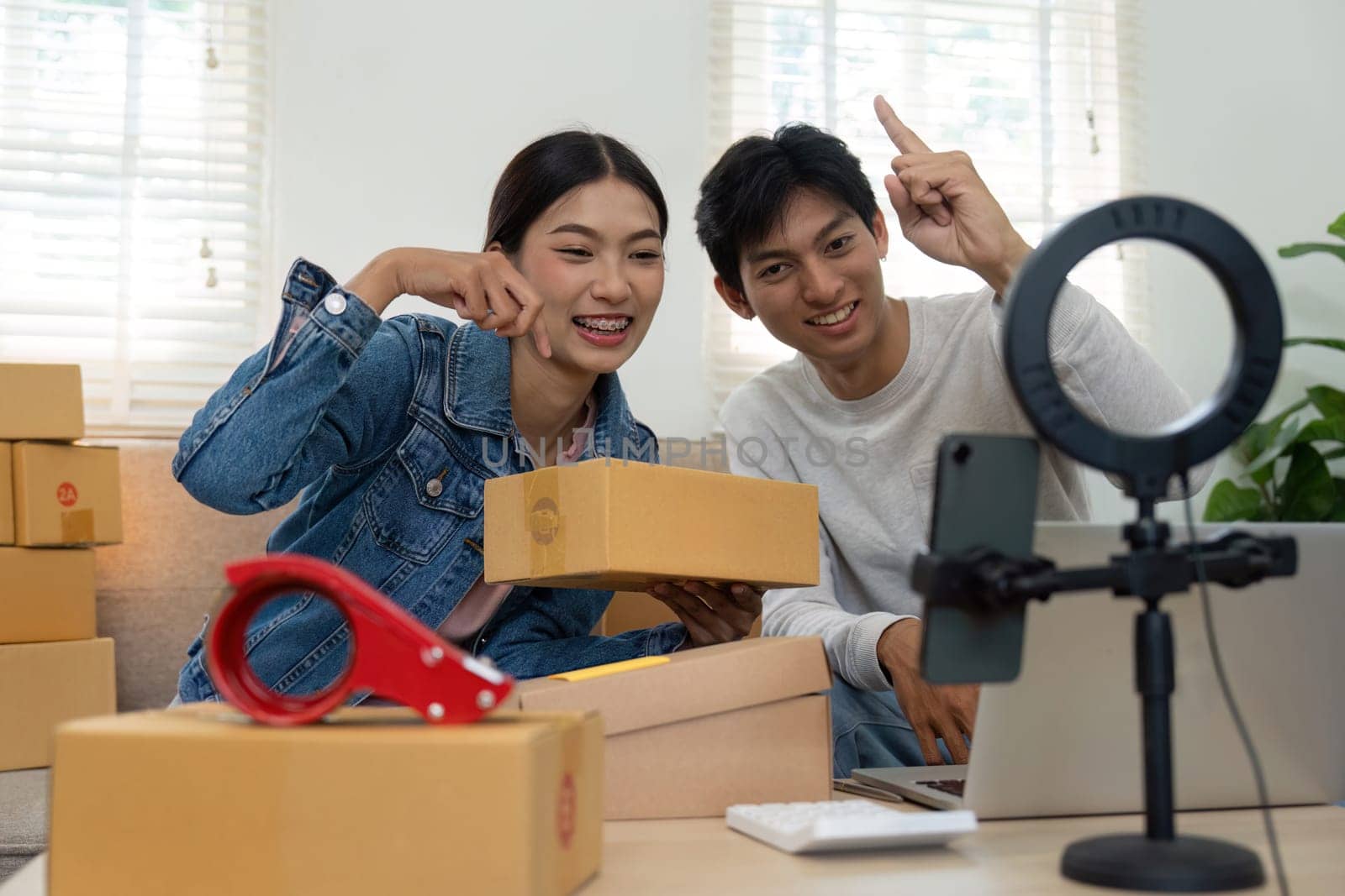 The duo prepares their workspace for an exciting product showcase, emphasizing connectivity and engagement in modern marketing strategies through live streaming.