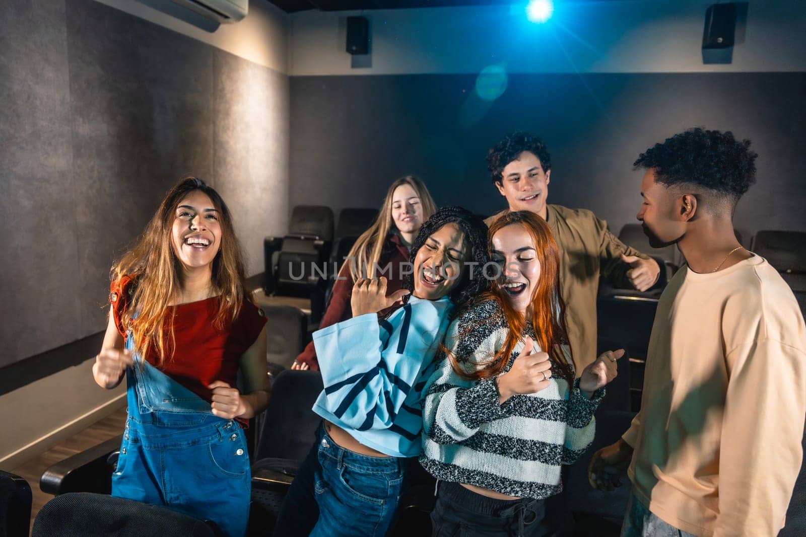 Group of friends enjoying a disco dance event at the cinema, laughing and having fun together