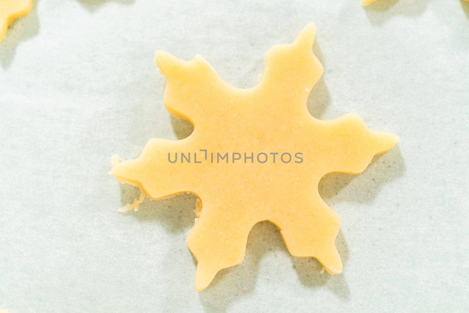 Close-up of a single star shaped sugar cookie cutout on parchment paper, showing the smooth dough surface.